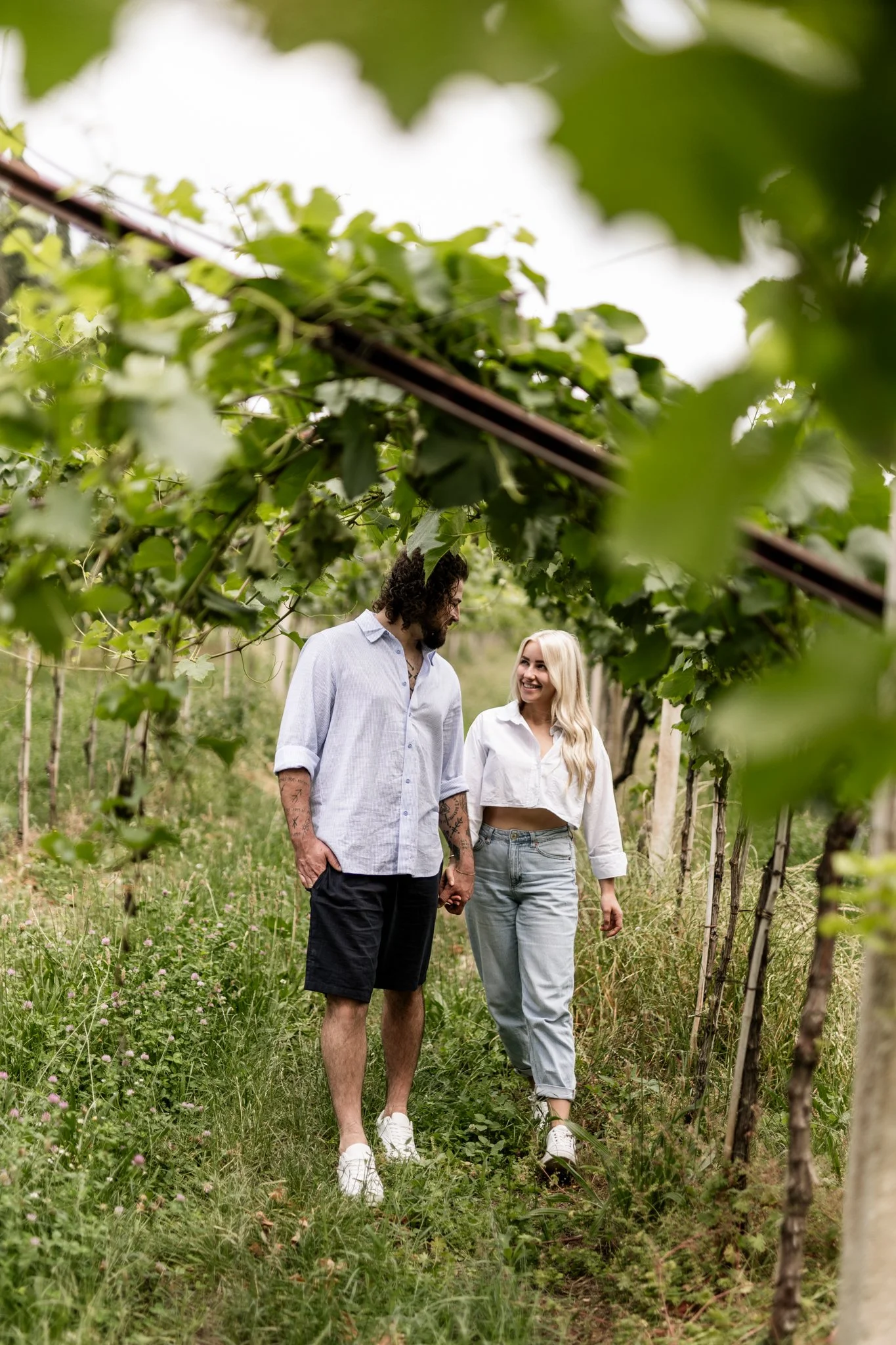 ein verliebtes Paar spaziert durch Weinreben in Italien