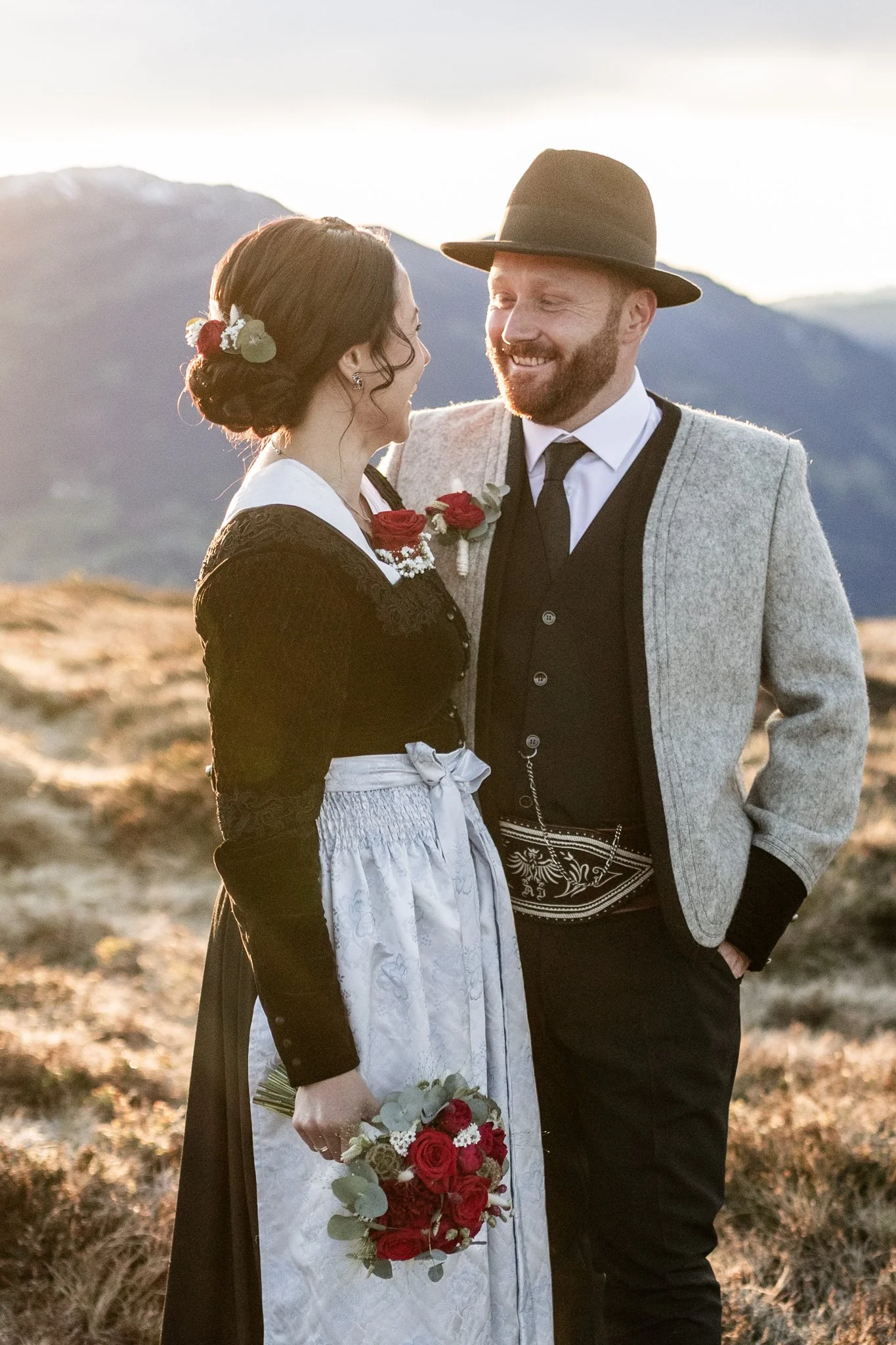 Zillertaler Hochzeitspaar in traditioneller Tracht und Hochzeitsblumenstrauß. 