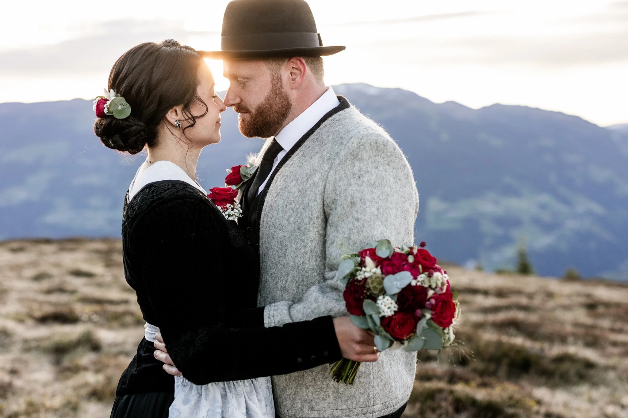 Liebe im Zillertal, Mann mit Zillertaler Tuxer Jacke und schwarzem Hut, Frau mit Reckl, Hellblauer Schürze und rotem Blumenstrauß zur Hochzeit. 