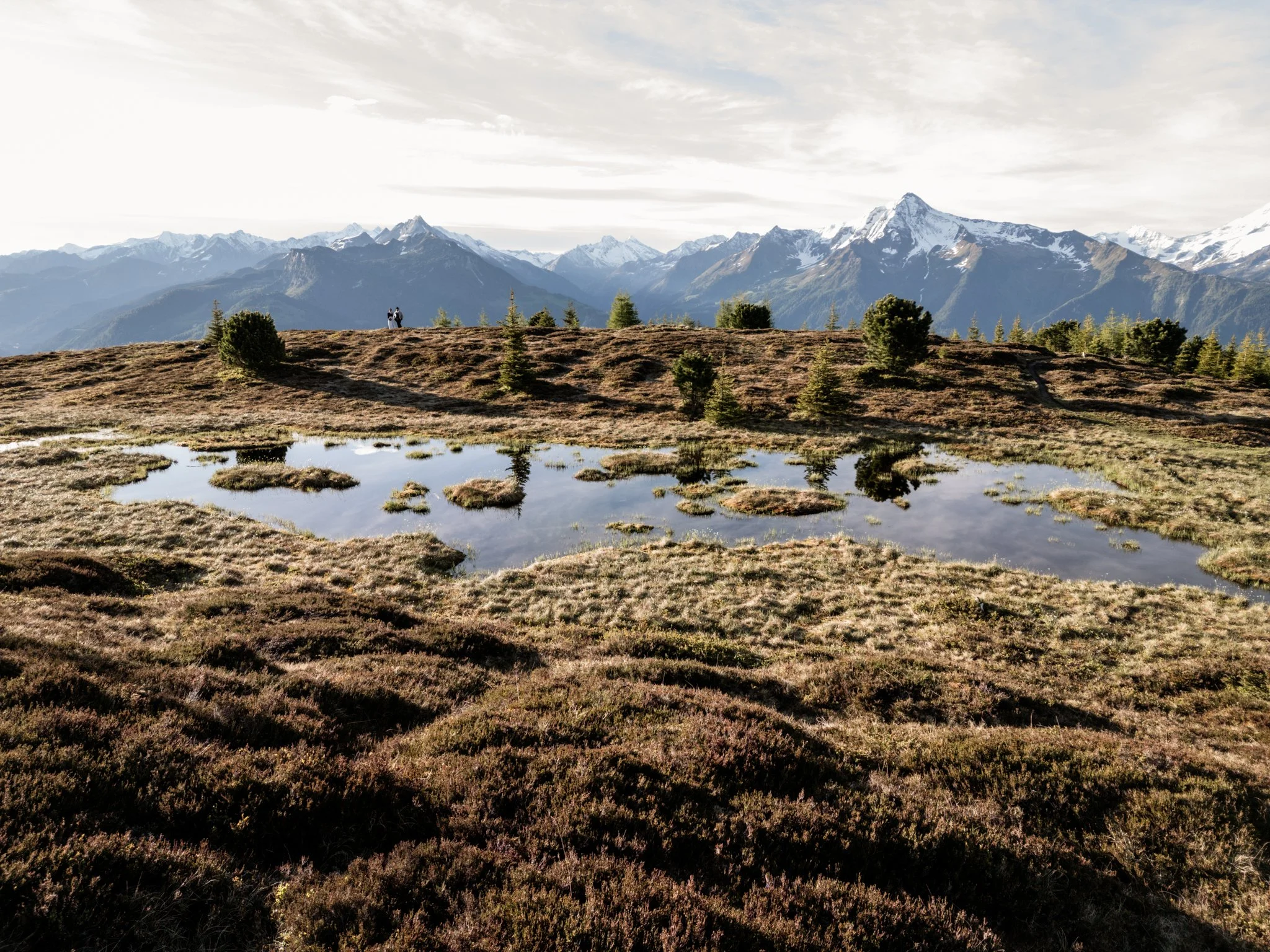 Spiegelung vom Brautpaar und der Berglandschaft in einem Bergsee. 