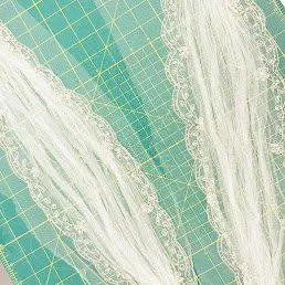 Delicate bespoke cup sleeves adorned with intricate lace trim, designed to enhance the elegance of a bridal gown. A perfect example of custom bridal tailoring and fine craftsmanship