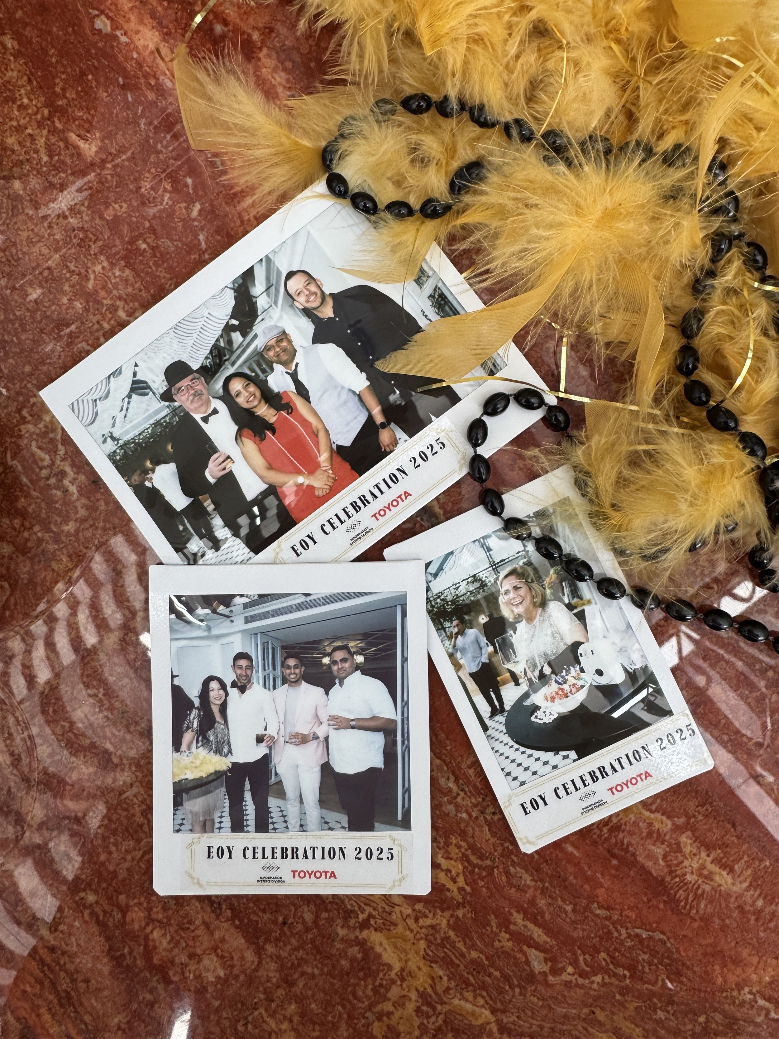 Photographs from a celebration event with people dressed in formal attire, along with decorative feathers and beads on a reddish-brown surface.