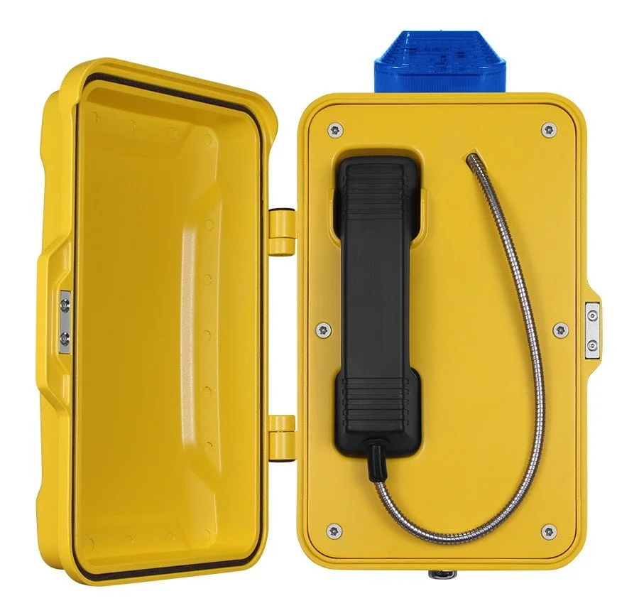 Yellow emergency lift to call telephone with a black handset and a metal cord inside a yellow case.