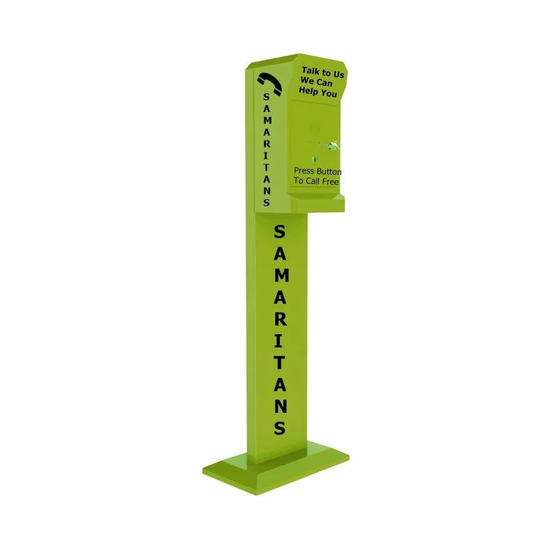 A green emergency phone booth labeled "Samaritans" with a sign saying "Talk to Us We Can Help You" and a call button to call free.
