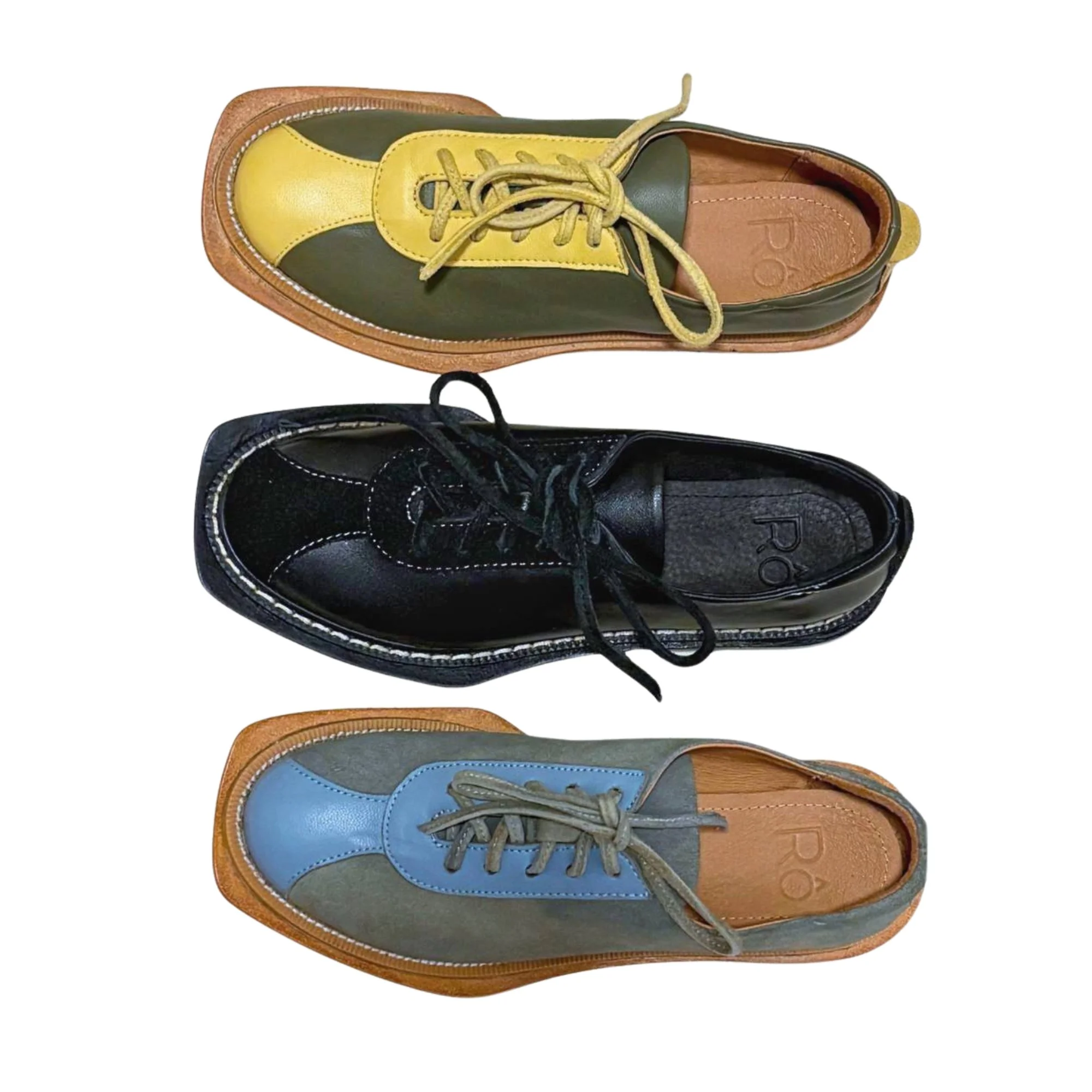 Two leather shoes, one yellow and gray, the other black with white stitching, photographed from above.