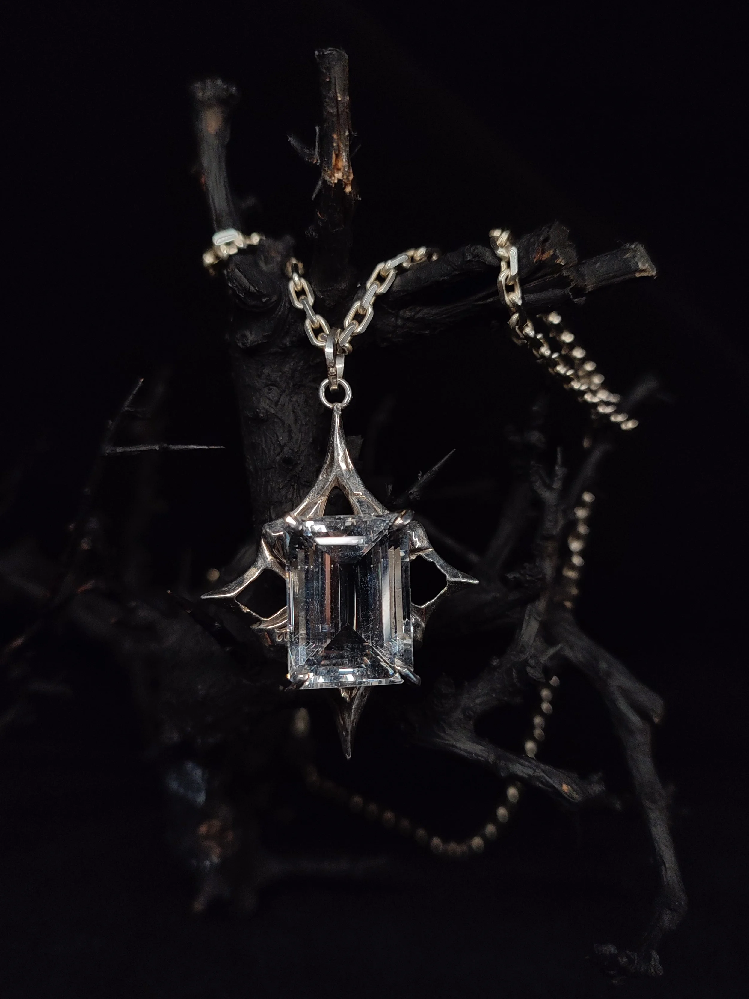Chaine avec pendentif Shrine, bijou original et unique de la créatrice WIT joaillerie en argent massif 925 surmonté d'une pierre précieuse, une aigue marine rectangulaire présenté dans une ambiance sombre et gothique.