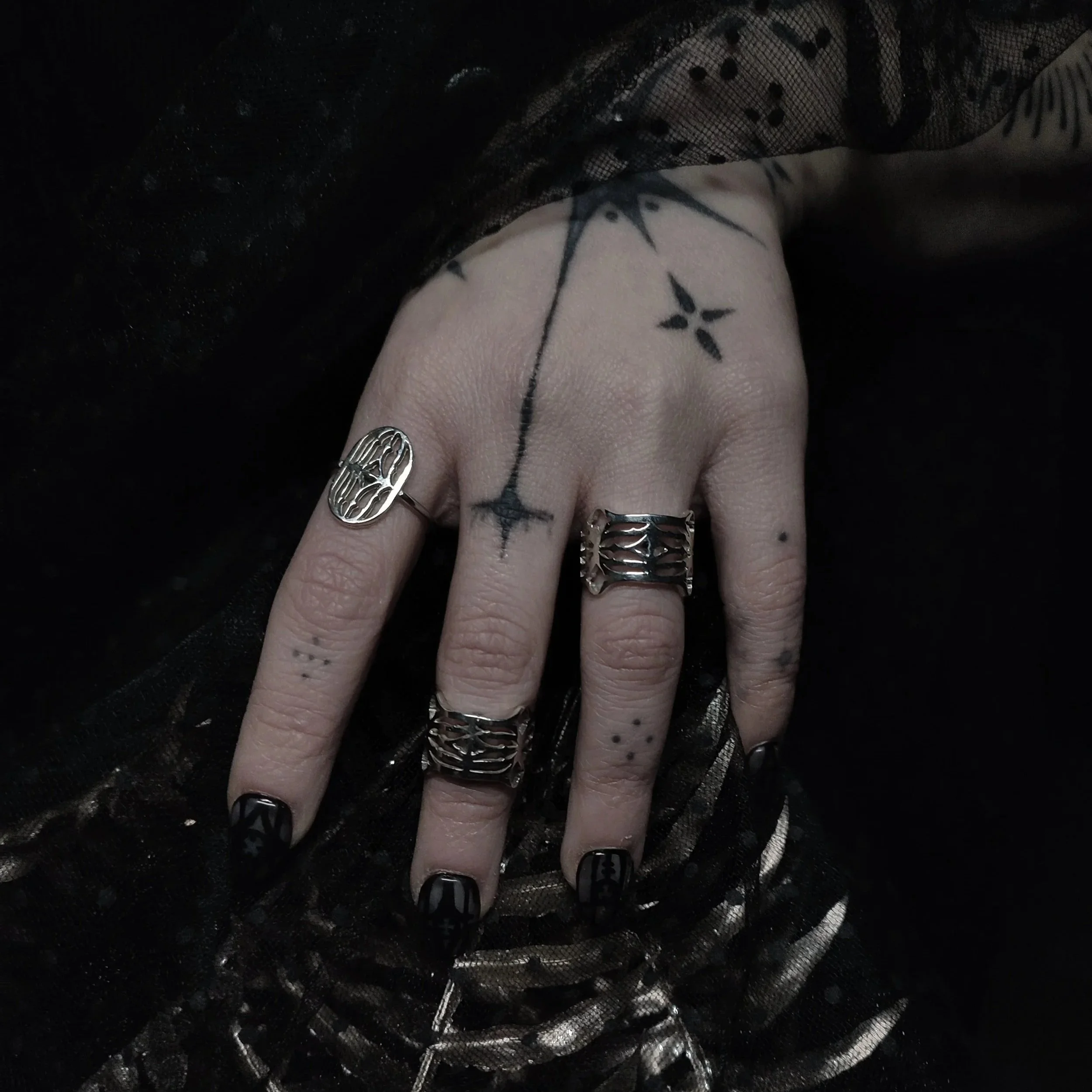 Main présentant les différentes formes et design des bagues Cluny en argent massif 925 création originale WIT s'inspirant du musée du moyen-âge de Cluny à Paris