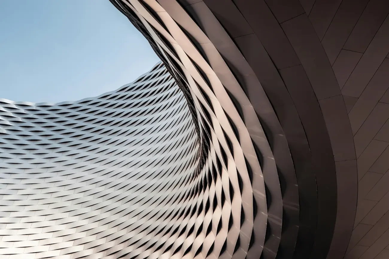 Ansicht eines modernen Gebäudes mit gewellter Fassade und einem spiralförmigen Design, aufgenommen von unten.