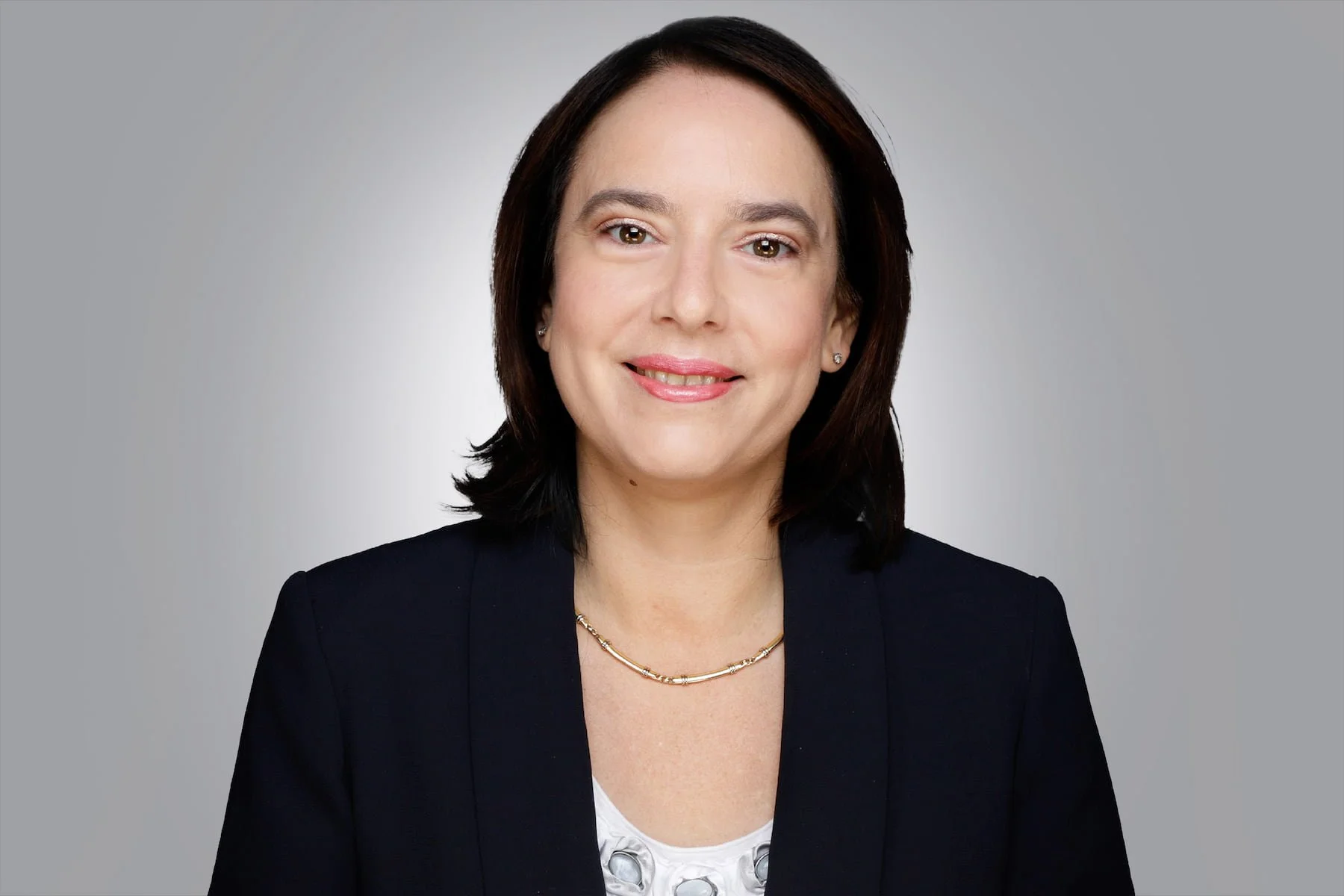 Portrait von einer Frau, mit freundlichem Gesichtsausdruck und schulterlangen schwarzen Haaren.