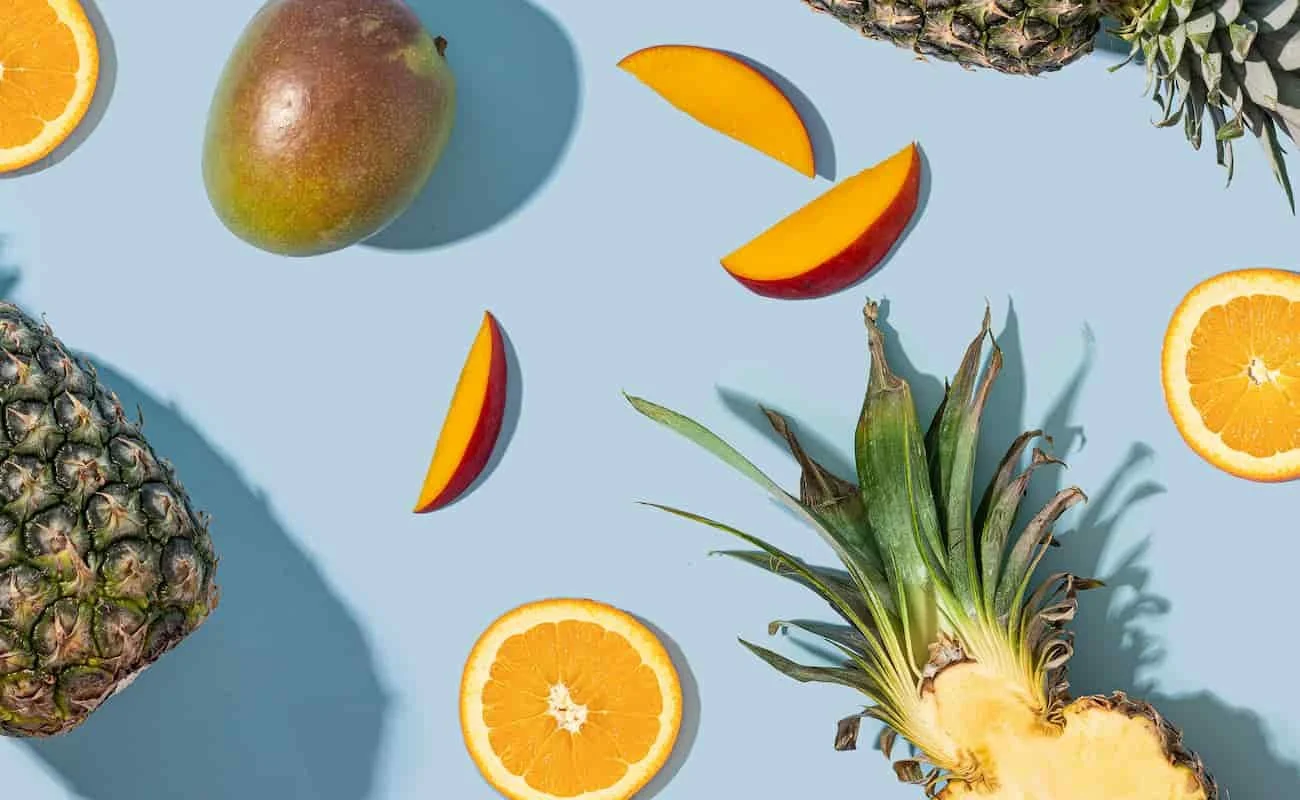 Eine bunte Obstmischung aus Ananas, Nektarinen und Orangen, die aufgeschnitten wurden