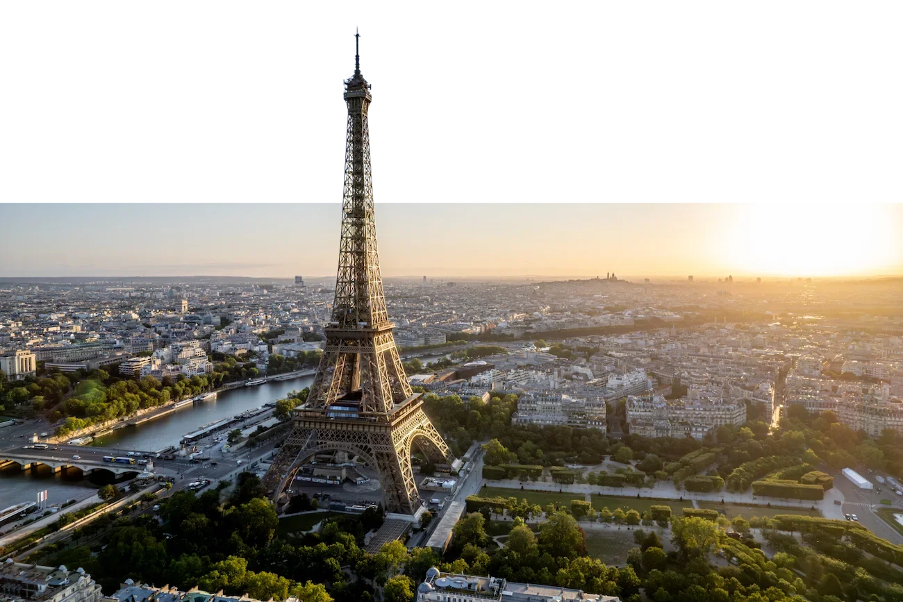 Luftaufnahme des Eiffelturms bei Sonnenuntergang in Paris, Frankreich mit Stadtansicht und Uferbereich der Seine.