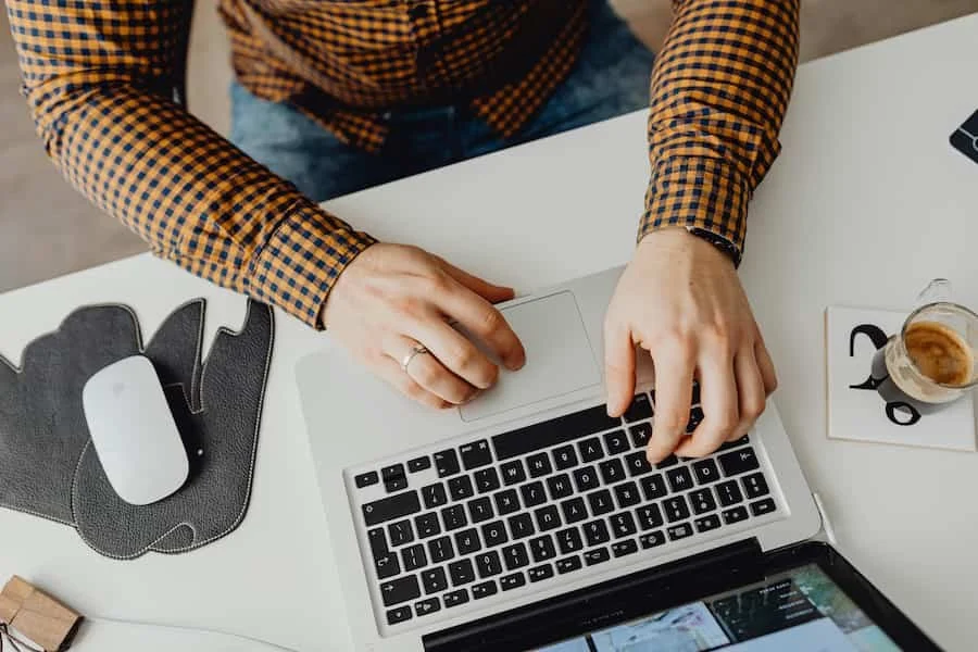 Nahaufnahme von Händen eines Mannes, de auf einer Tastatur tippen