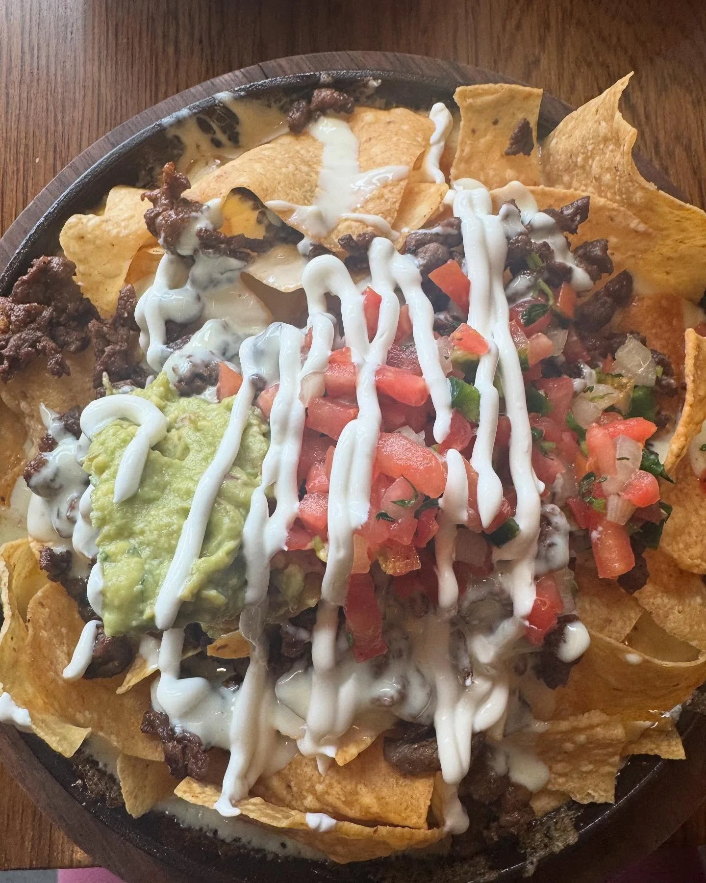 Skillet nachos but with queso fundito. Very delicious, but we all know if we don&rsquo;t eat the gooey cheese within two minutes of drop off we&rsquo;re prying it off the pan - which is exactly what I did for my leftovers. 🤩 @casa.alejo.nwa #nachos 