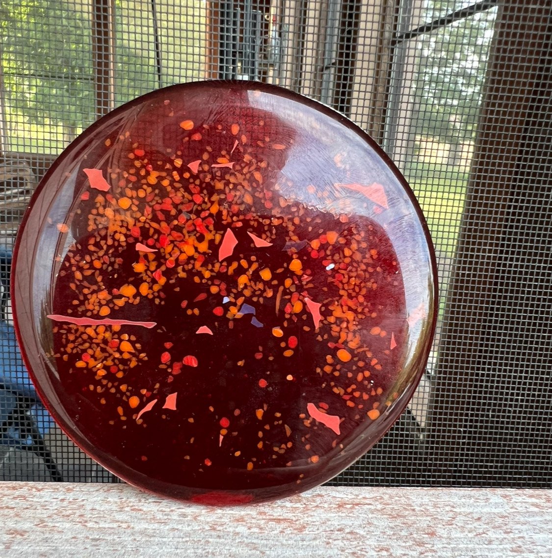 This 3" fused glass orb is the centerpiece for "Icarus", which is also shown and described here in the gallery. The orb comprises three layers of red bullseye glass with various sizes and colors of frit and confetti between and atop the layers and f