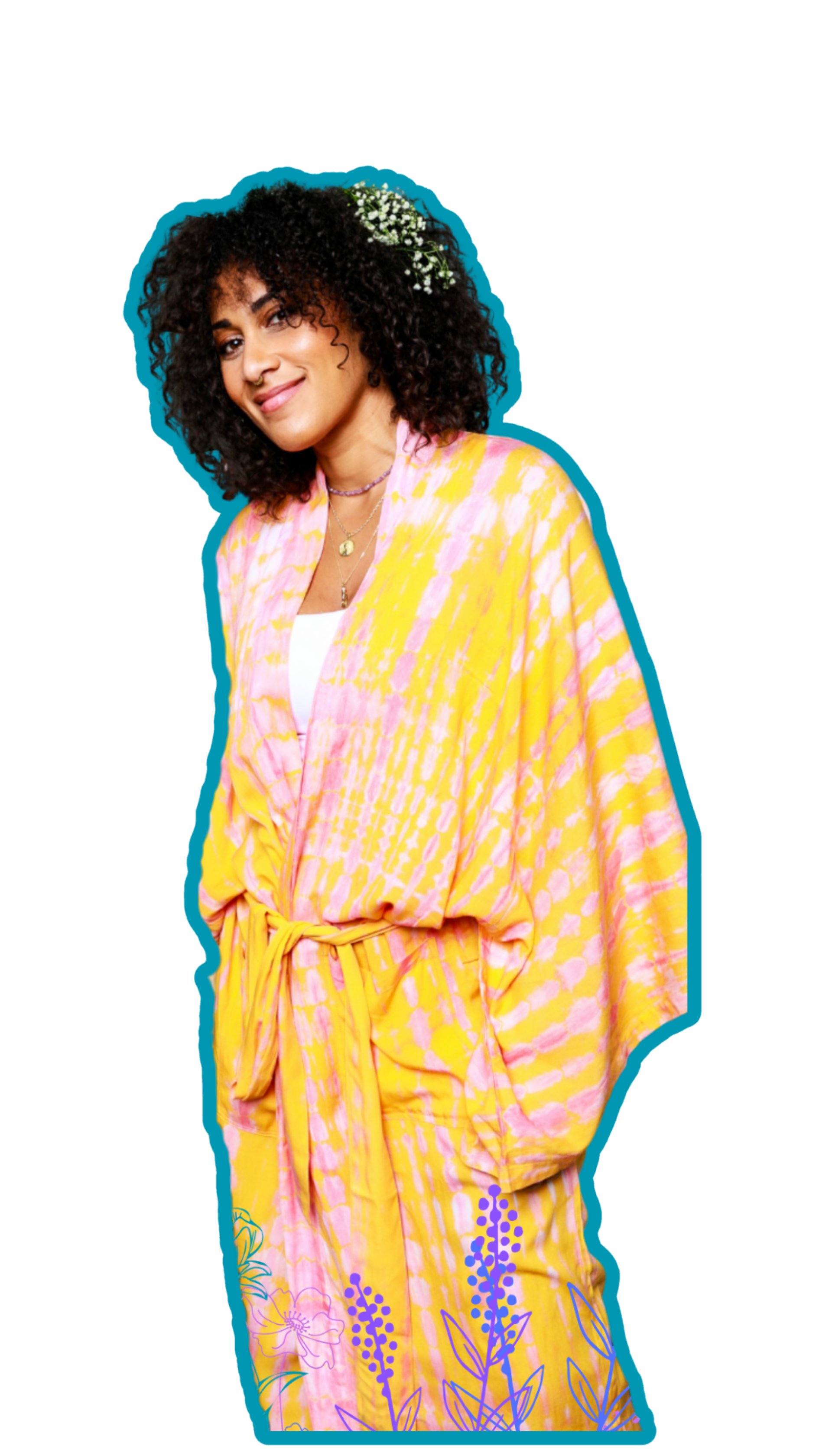 Young woman with dark, curly hair, smiling, wearing a yellow and pink tie-dye patterned dress, accessorized with layered necklaces and flowers in her hair.