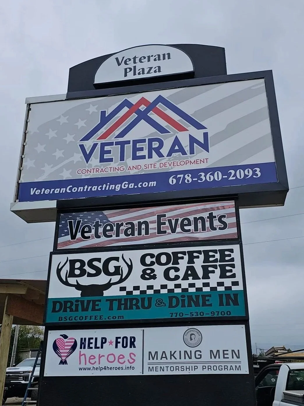 Signboard for Veteran Plaza and various businesses, including Veteran Contracting, a coffee and cafe shop, and a mentoring program for men.