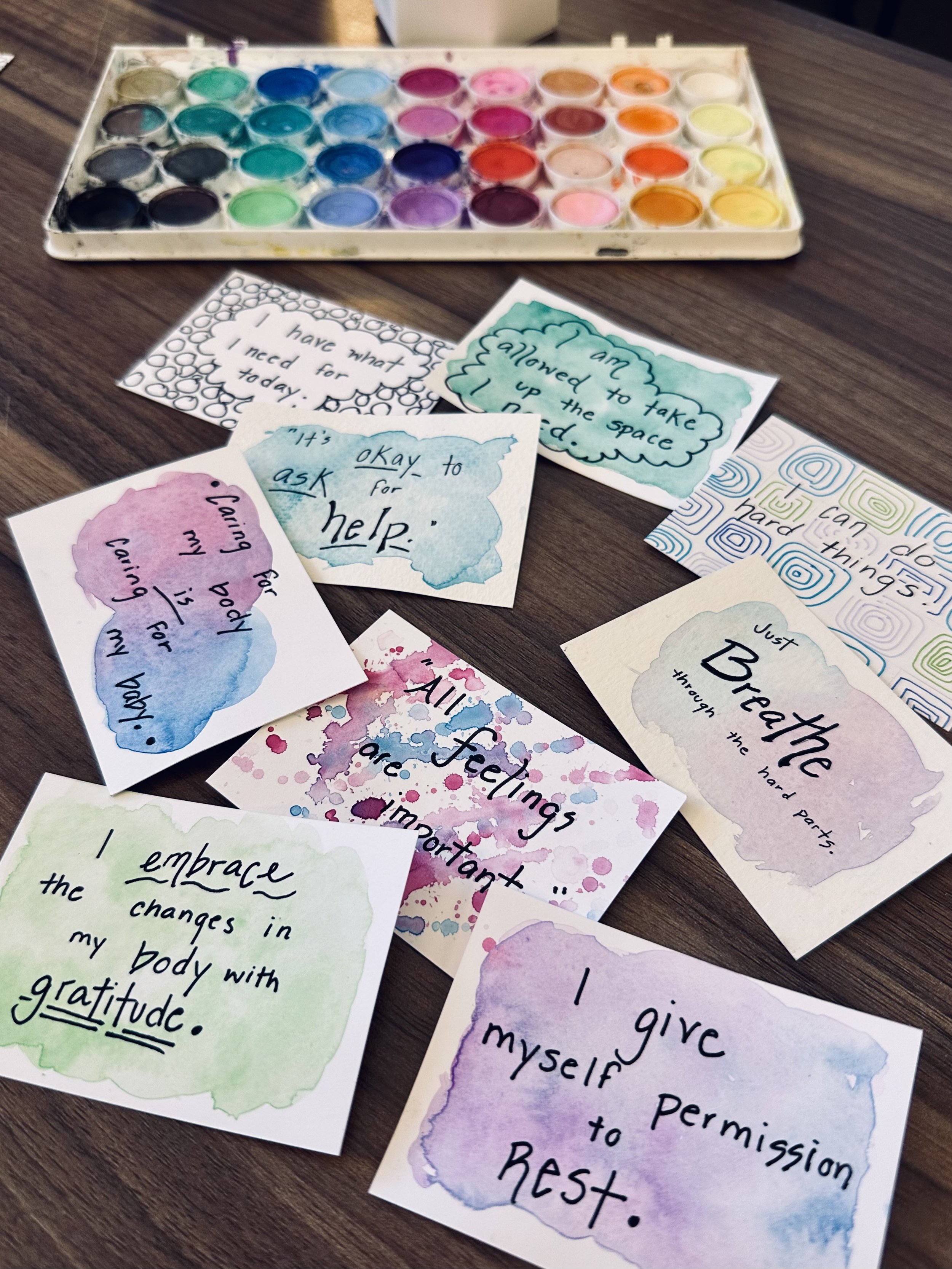 Group of positive affirmation cards and watercolor paints in an art therapy office in Herndon Virginia