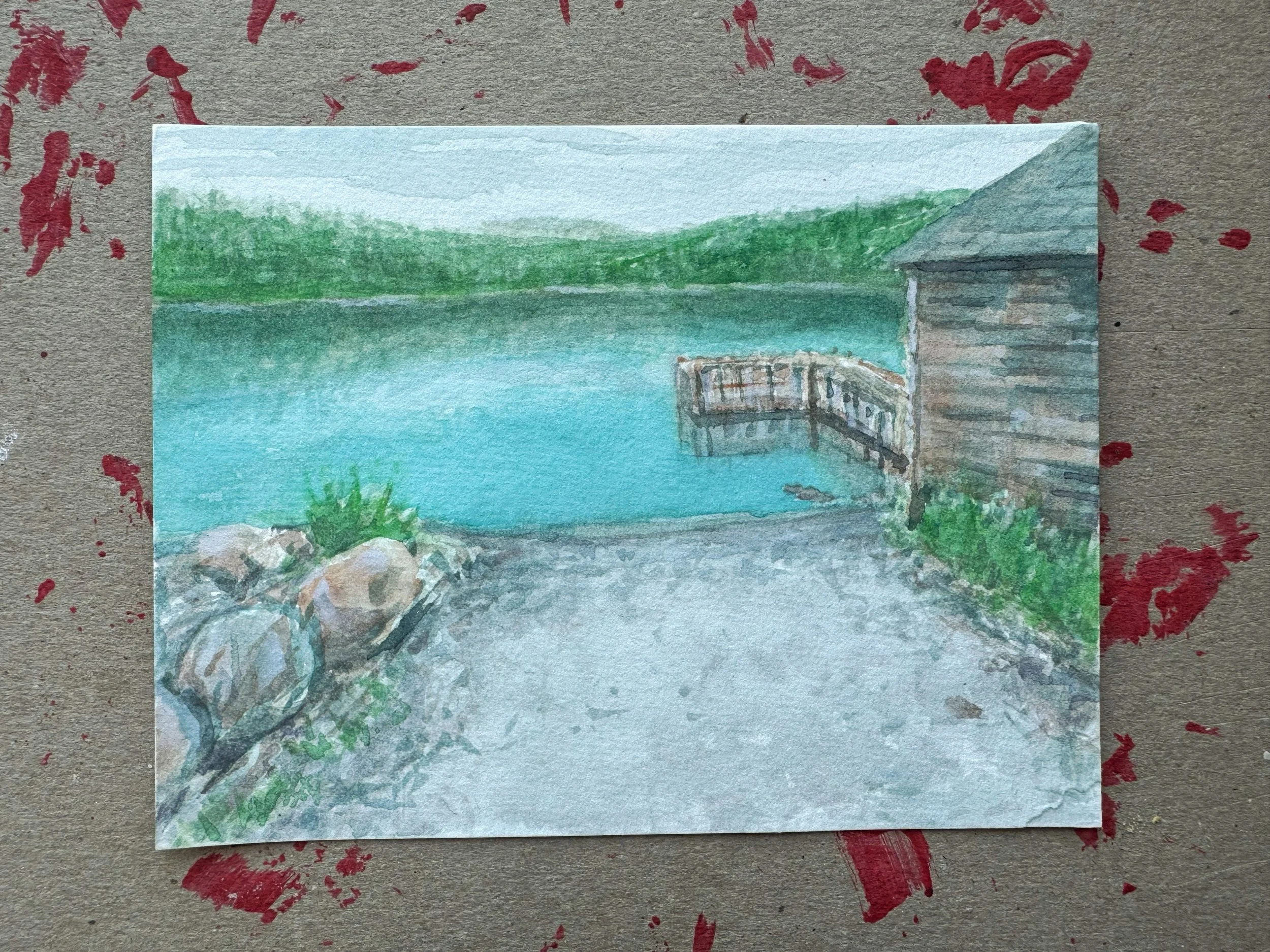 Watercolor painting of a lakeside scene with a wooden dock and a boathouse, surrounded by greenery and rocks.