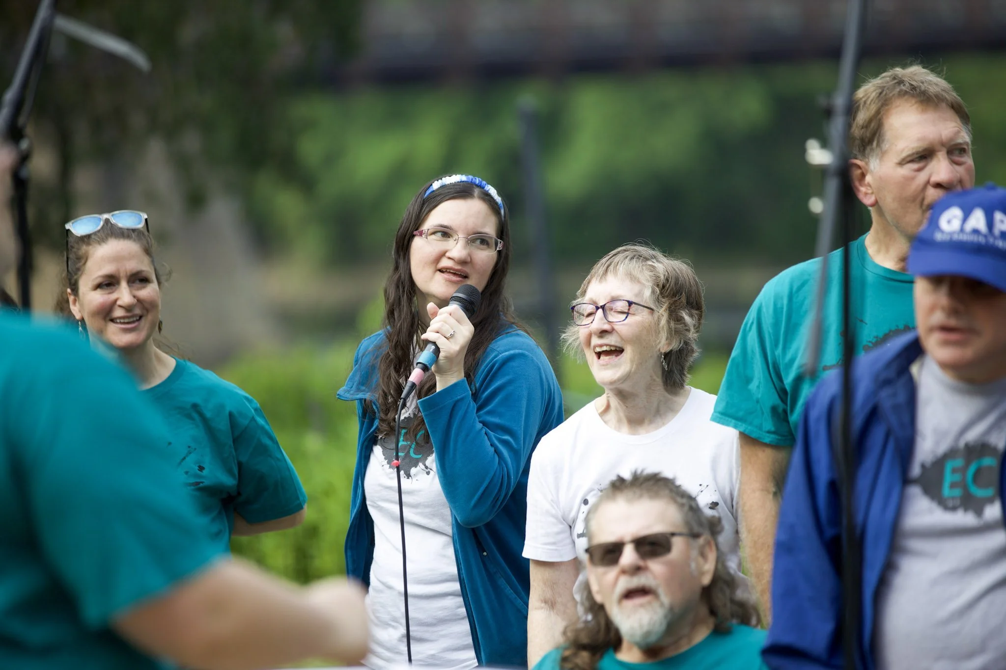 collective choir singing at phoenix park in eau claire wisconsin outdoors with microphones.