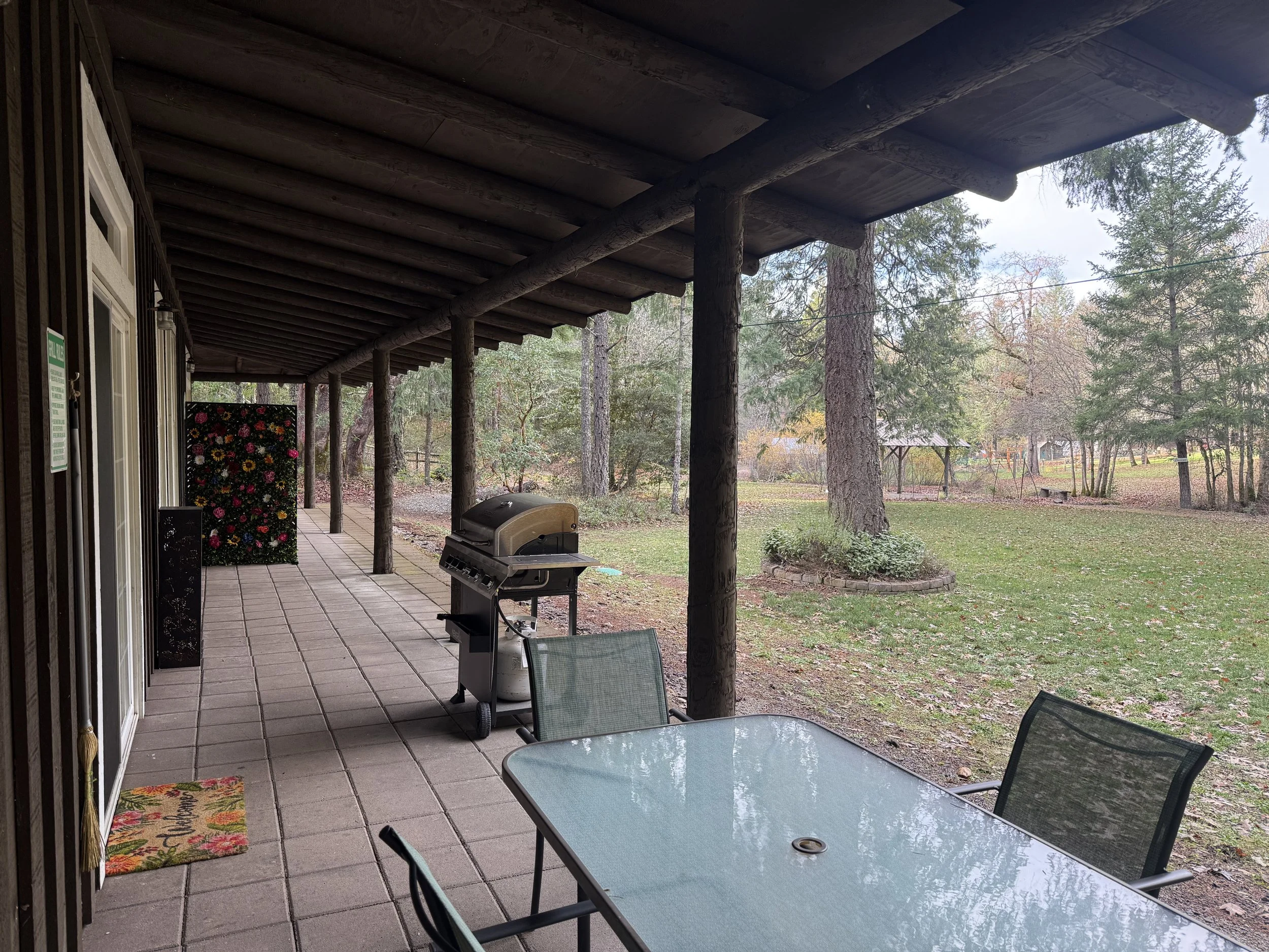 Shaded patio dining area overlooking forested grounds.