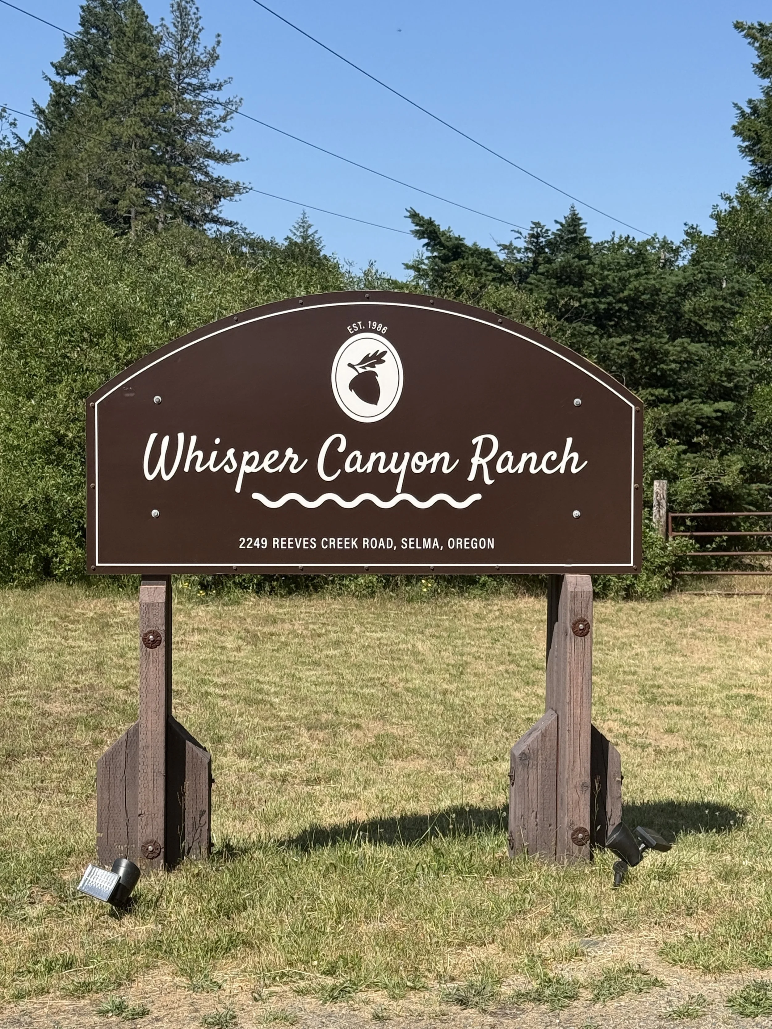 Whisper Canyon Ranch entrance sign on scenic country roadside.