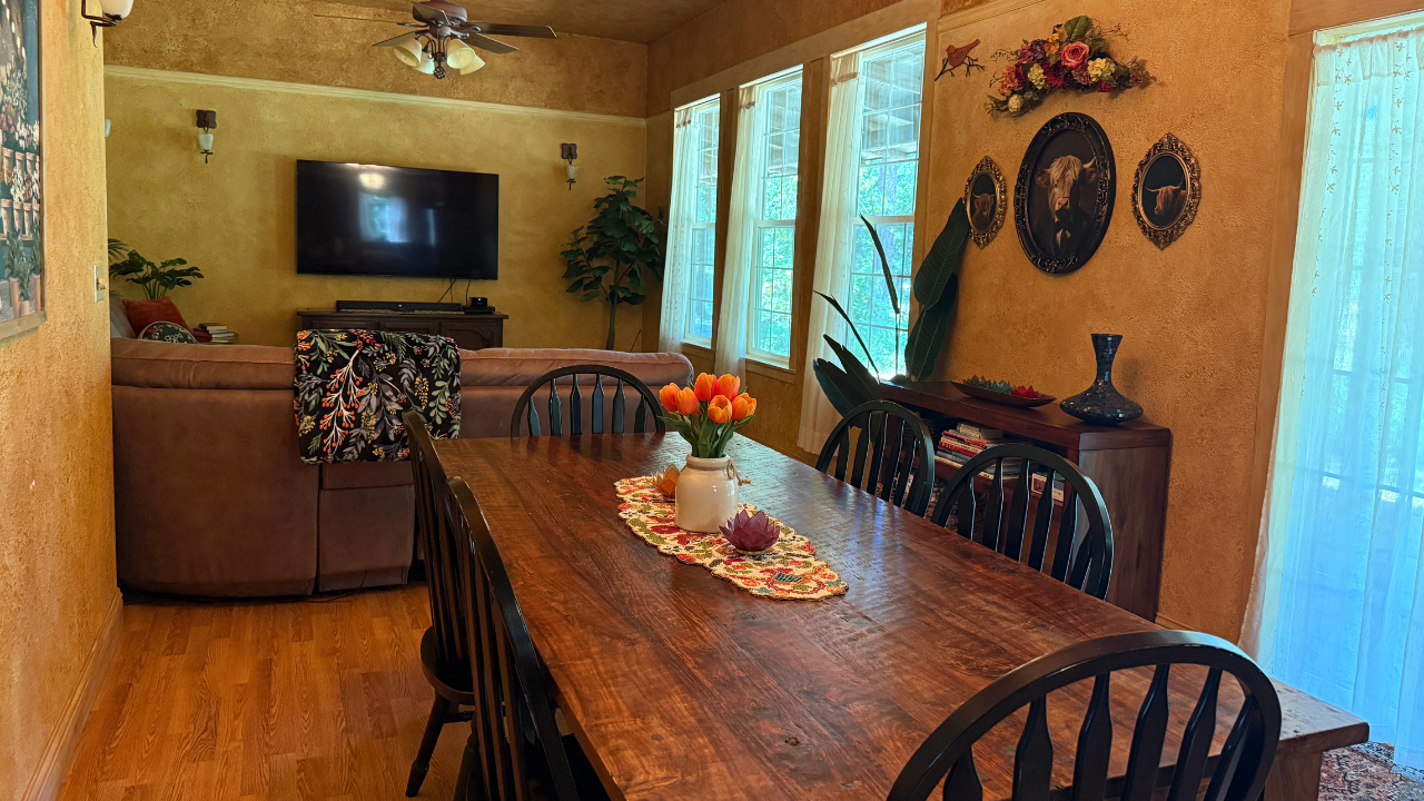 Dining area with large wooden table overlooking the living room.