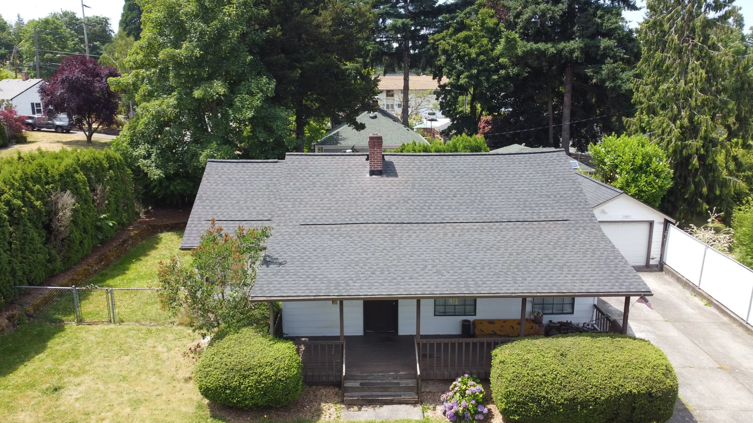 Aerial view of a single-story house with a gray shingled roof replaced by AE&I Roofing and Construction