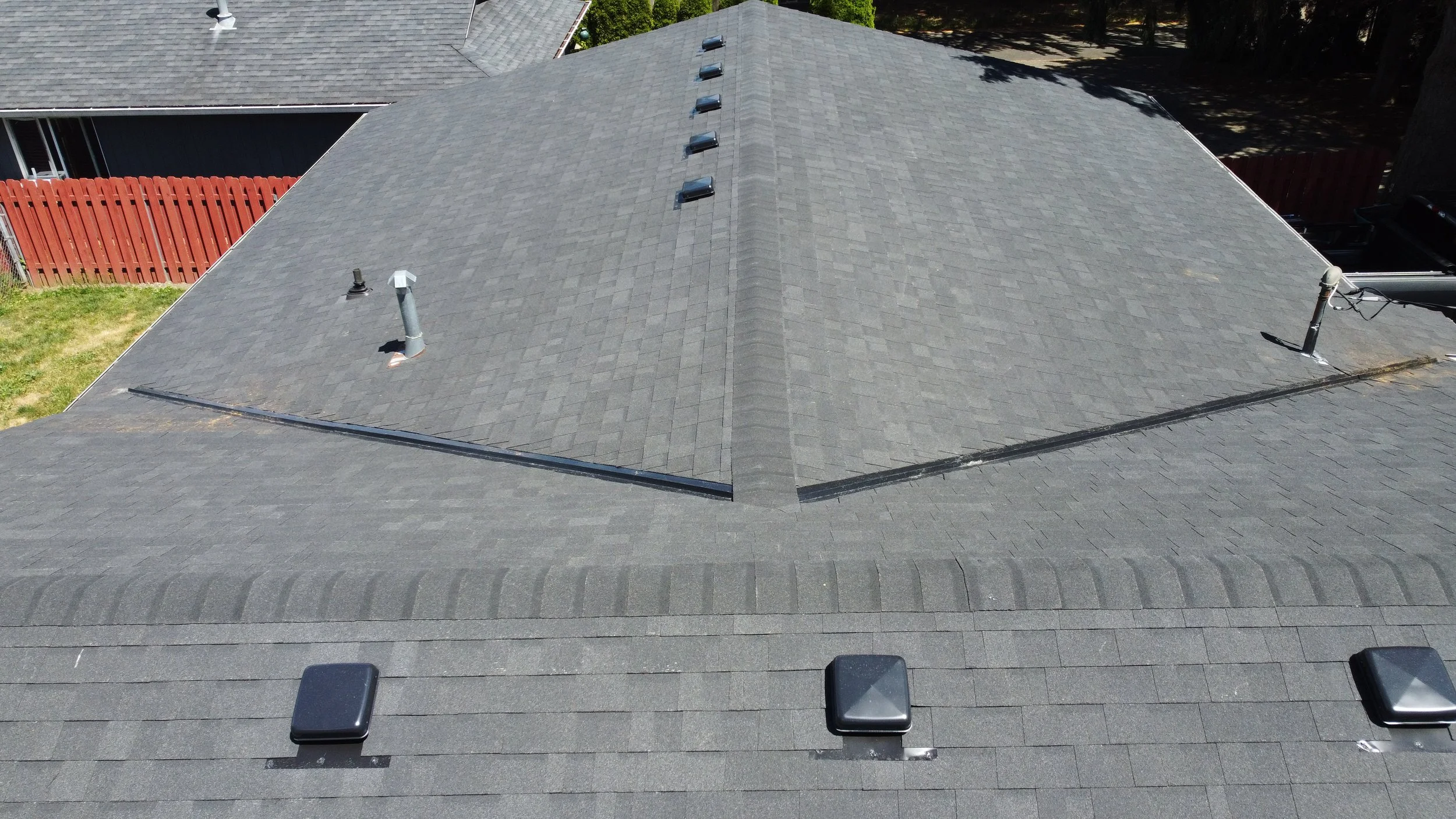 Aerial view of a grey shingled GAF roof installation by AE&I Roofing and Construction
