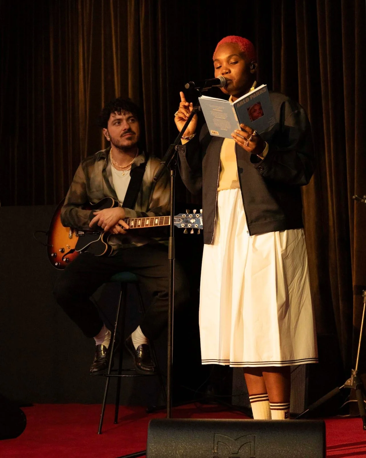 Author reads on stage Miu Miu Library club