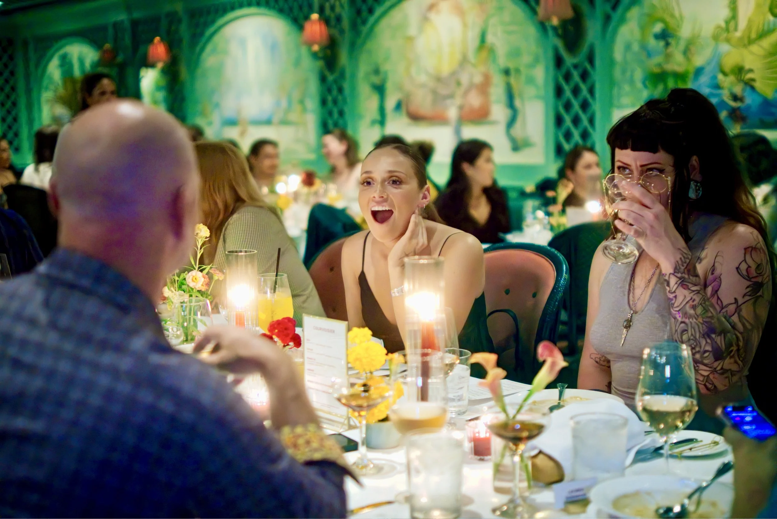 A guest looks pleasantly surprised by what another guest said across the table