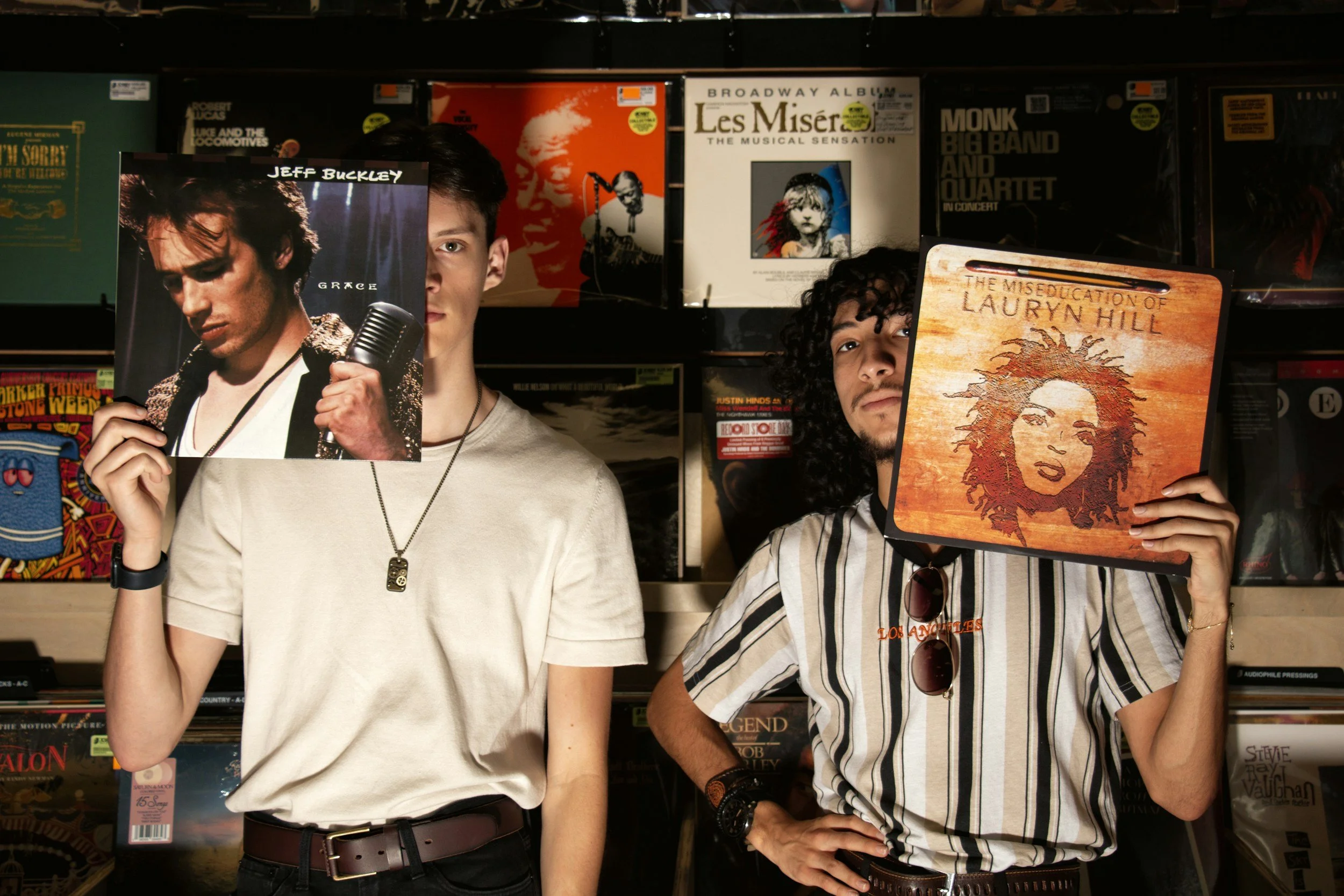 Two people holding up albums