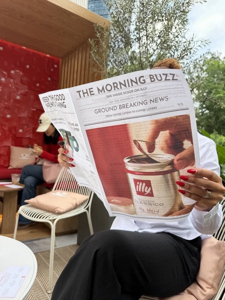 Person reading Illy newspaper