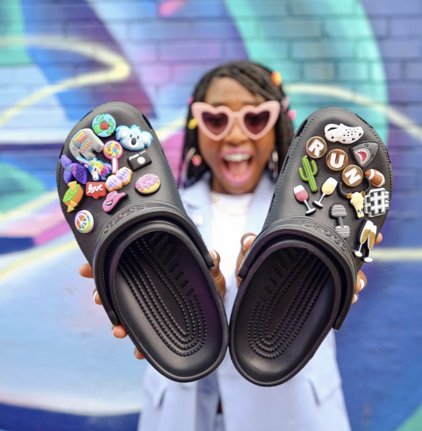 Crocs fan holds out her pair of crocs, featuring newly designed and personalized charms, or Jibblitz