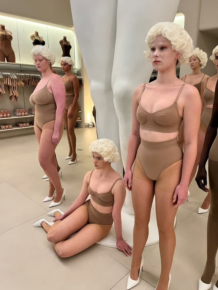 Models of all body types and ethnicities pose wearing Skims attire and Marilyn-Monroe style wigs