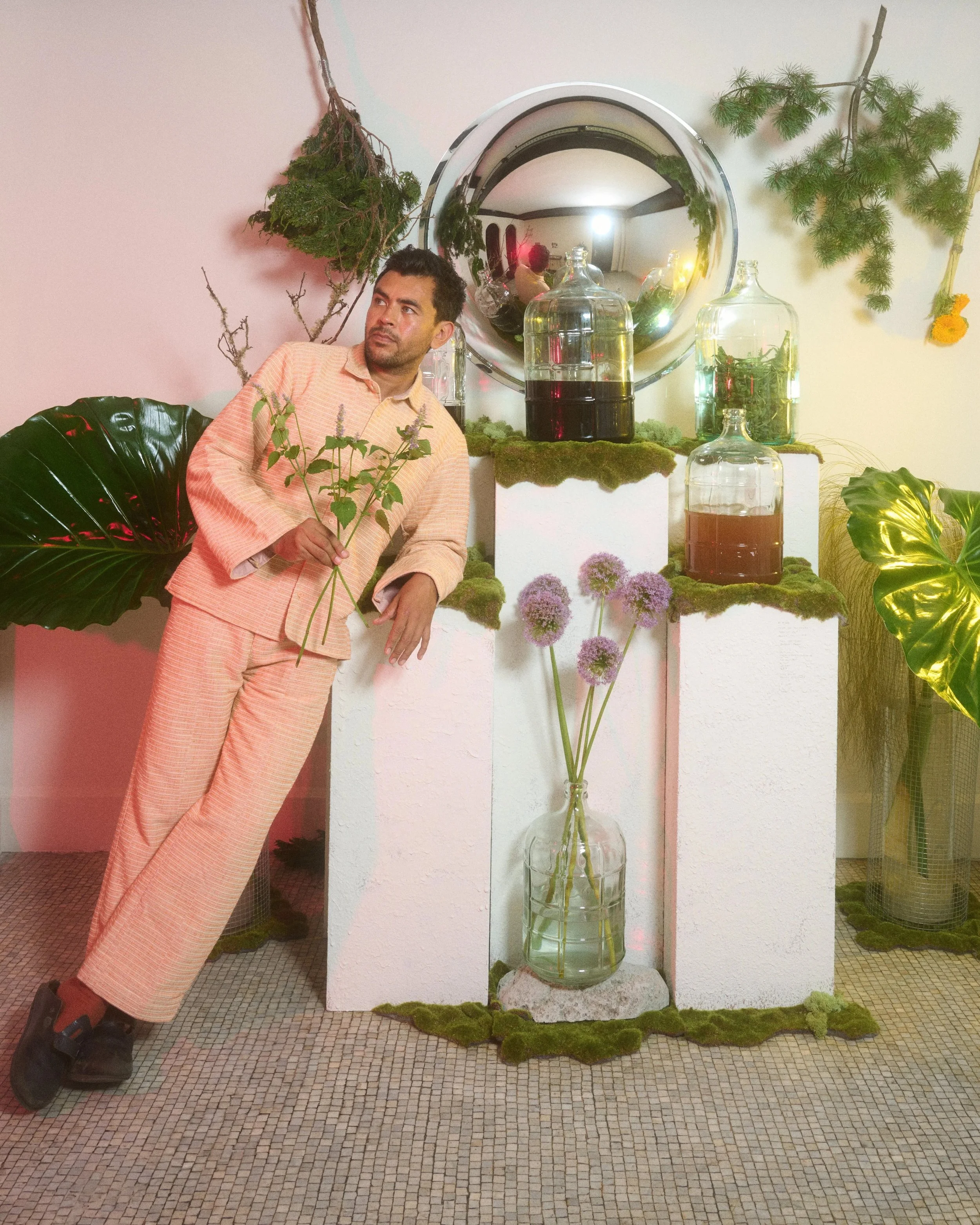 Ace Hotel Artist stands next to floral art exhibit