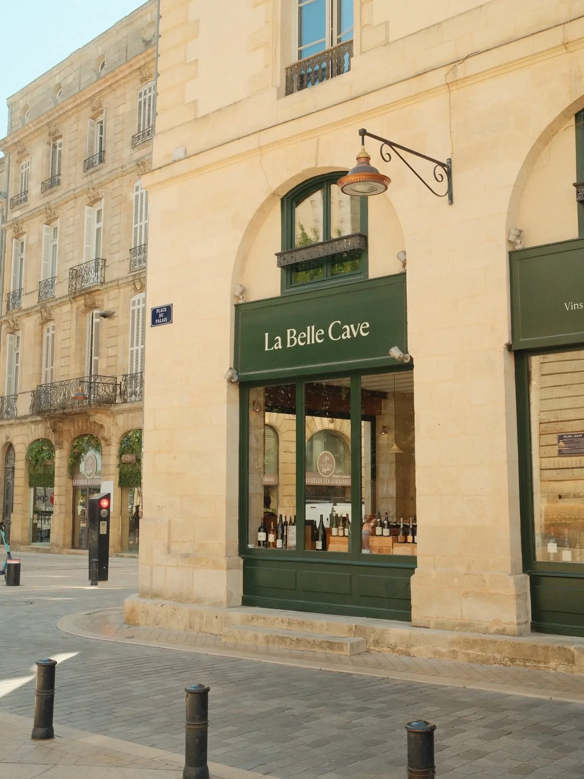 Façade d'une boutique appelée 'La Belle Cave' avec des bouteilles de vin dans la vitrine.