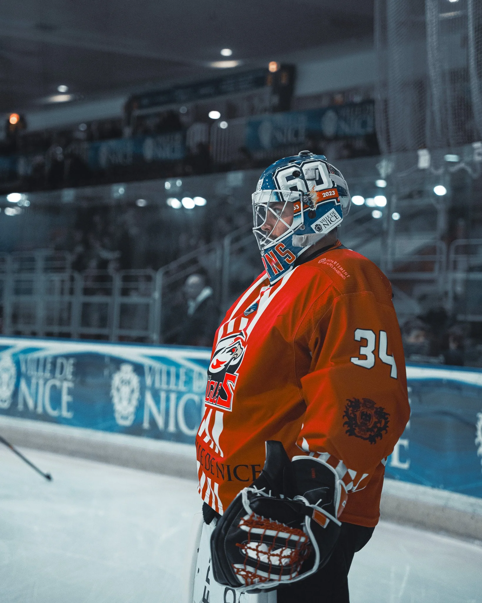 Joueur de hockey sur glace avec un maillot rouge et un casque sur la patinoire.