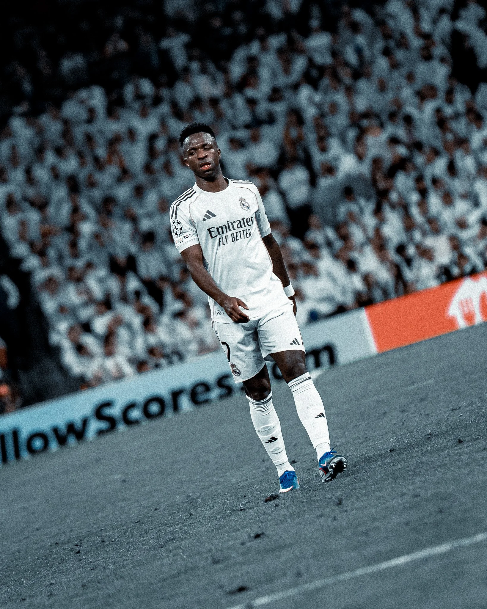 Joueur de football portant un maillot blanc de Real Madrid, en action sur le terrain lors d'un match.