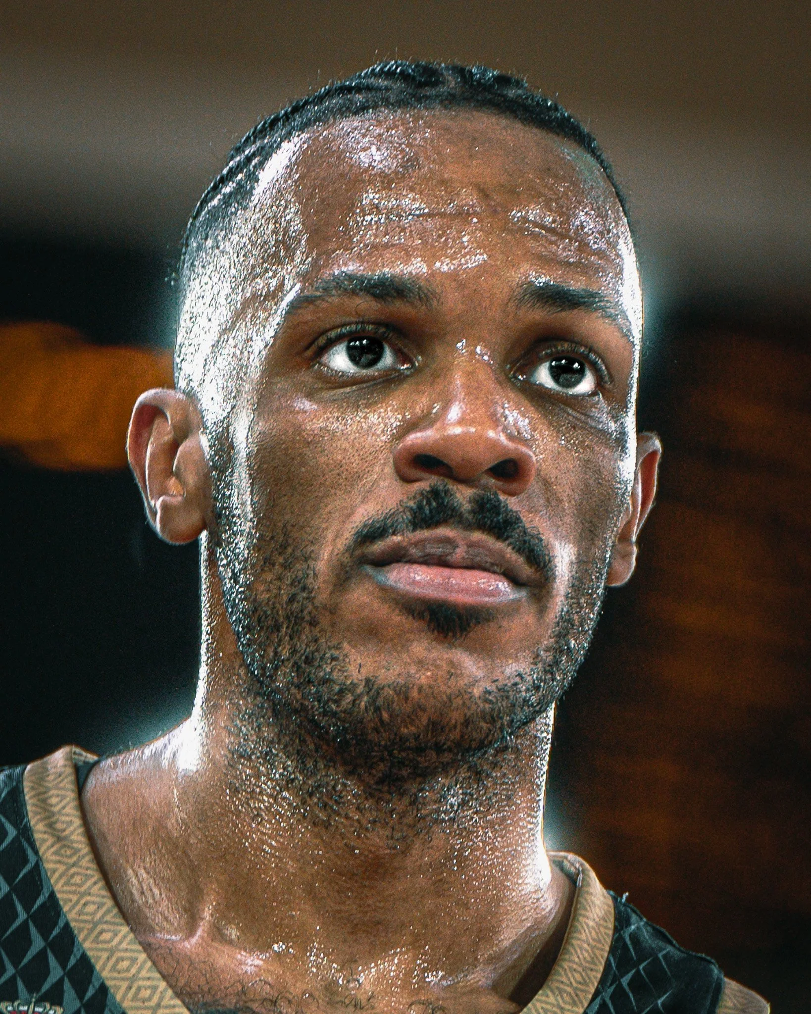 Un homme est en sweat à capuche, visage en sueur, regardant au loin.