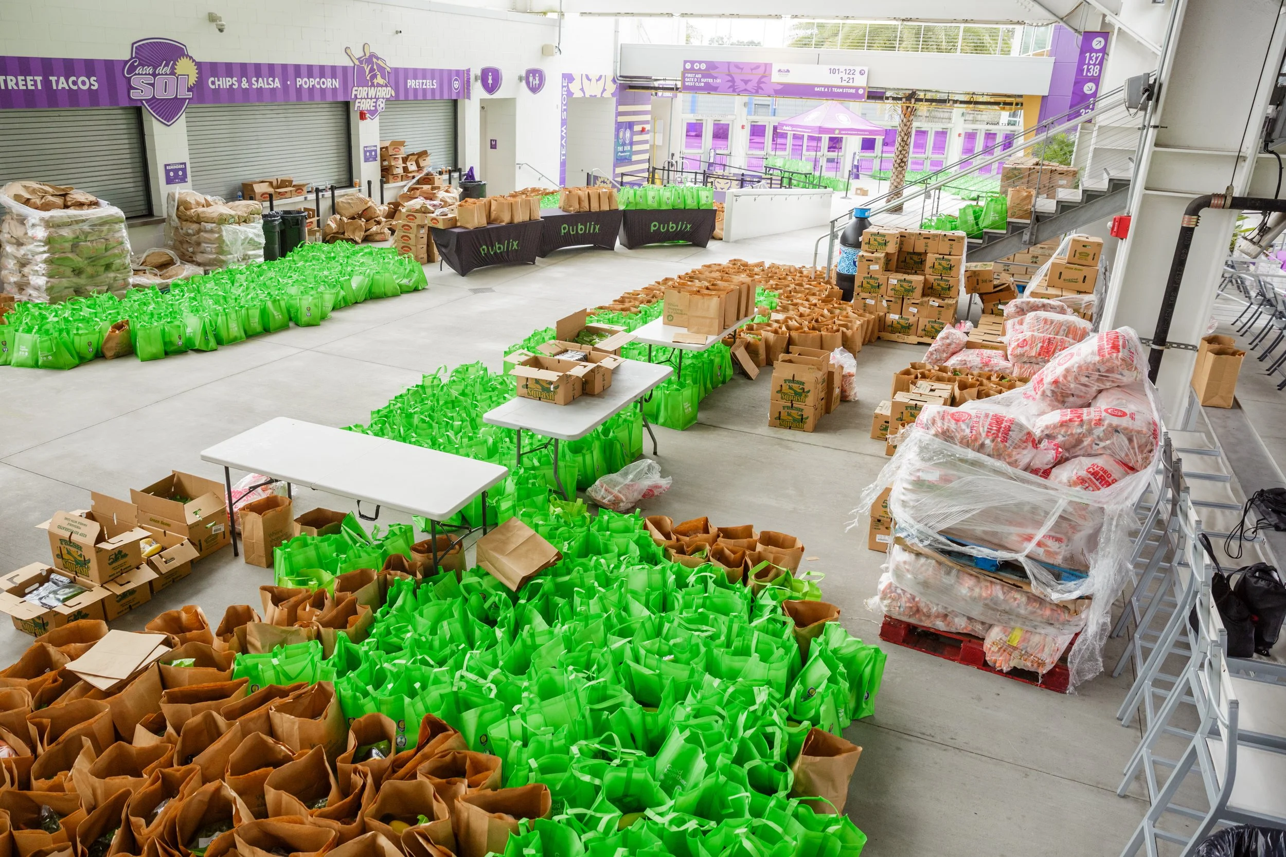 bags of groceries from Publix Grocery Store lined up on the concourse of the stadium ready to be donated to families at Thanksgiving time