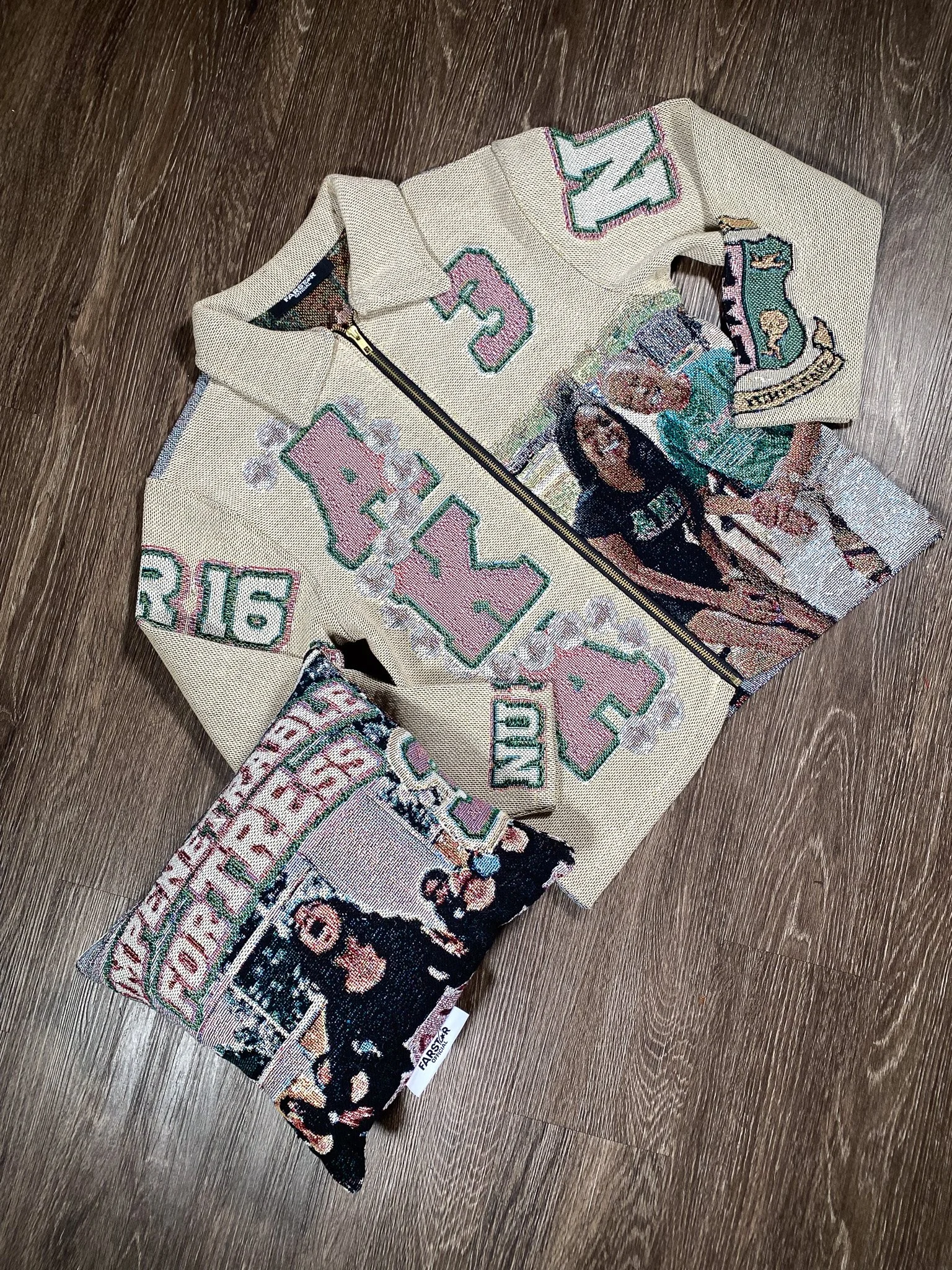 Part of an embroidered baseball cap with colorful designs, text, and images, resting on a dark wooden surface.