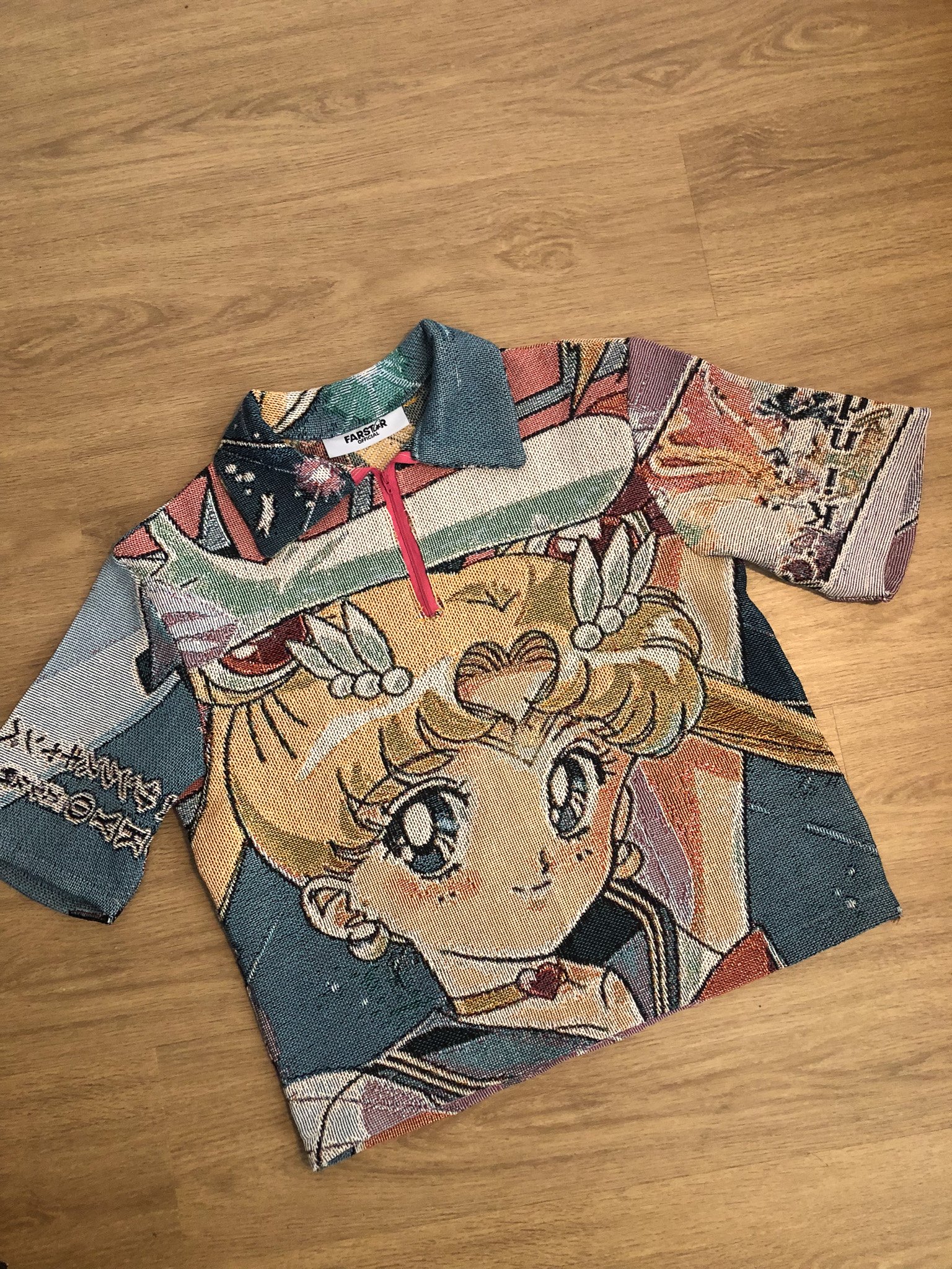 Fabric piece featuring a cartoon character design with a collar, partially folded on a wooden surface.