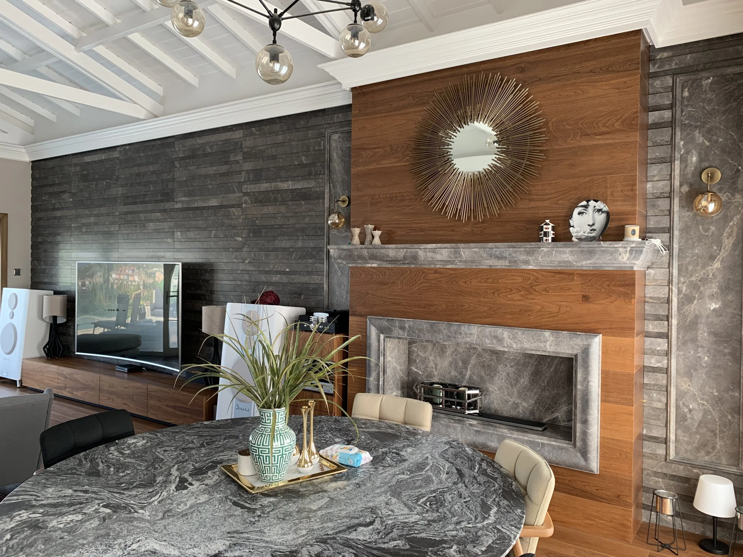View from the dining room of an eclectic modern rustic home. Warm walnut combined with grey toned marbles in decoration and furniture.