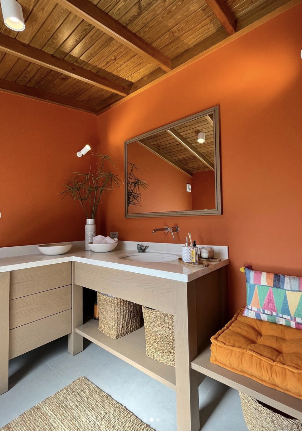 Modern bathroom with orange walls and oak cabinets
