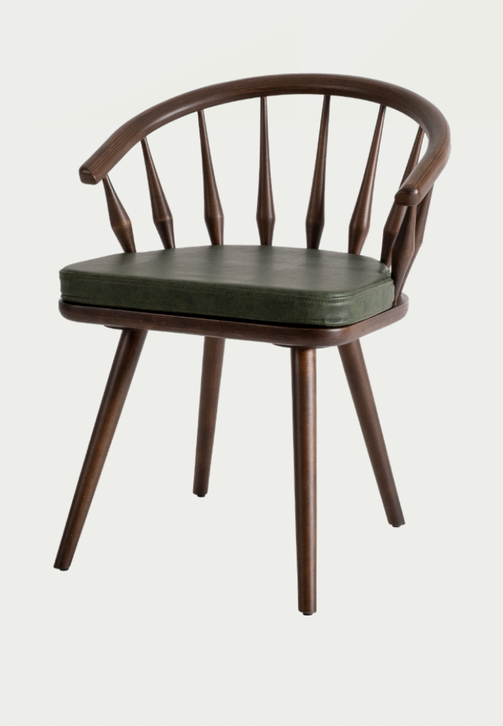 Artisan NOMO walnut dining chair with luxury dark green upholstery and steam-bent wood frame for high-end dining rooms by Nuovo Kitchens Vancouver.