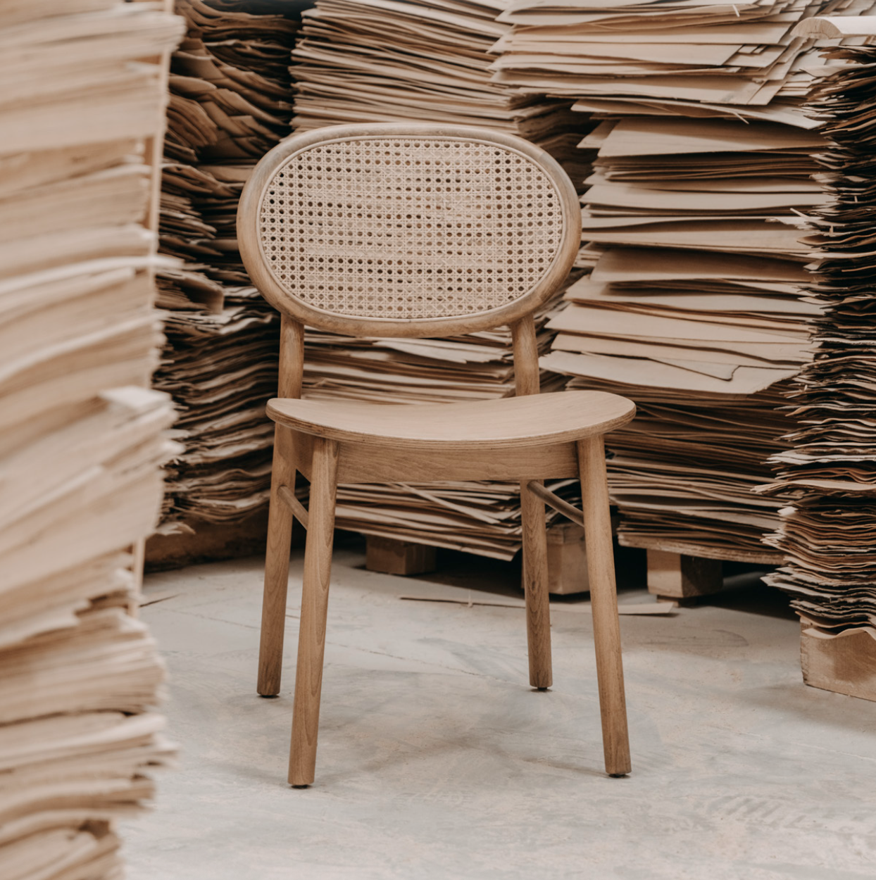 Luxury NOMO oak dining chair with natural Hazeran cane backrest and steam-bent wood frame for high-end dining rooms.