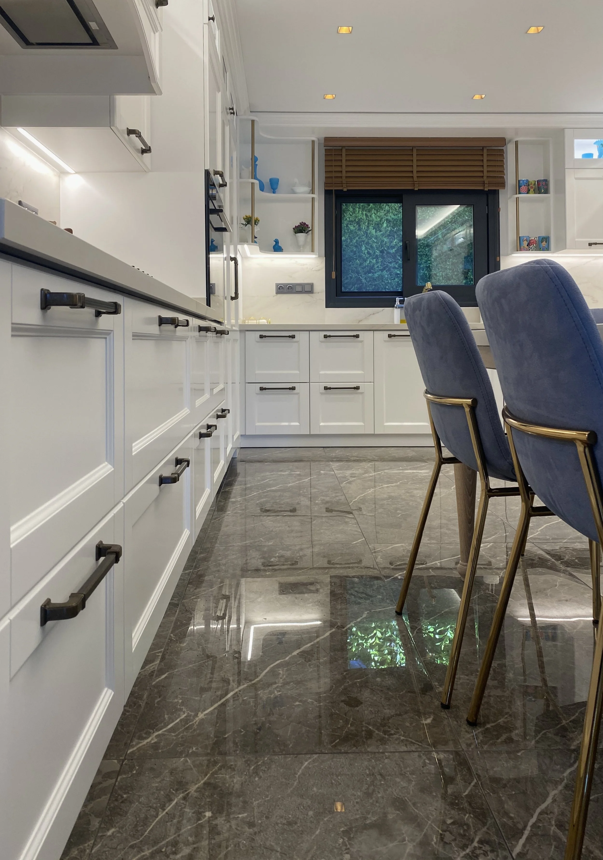 Soft off-white shaker cabinetry featuring traditional black Häfele hardware and a seamless full-height quartz backsplash.