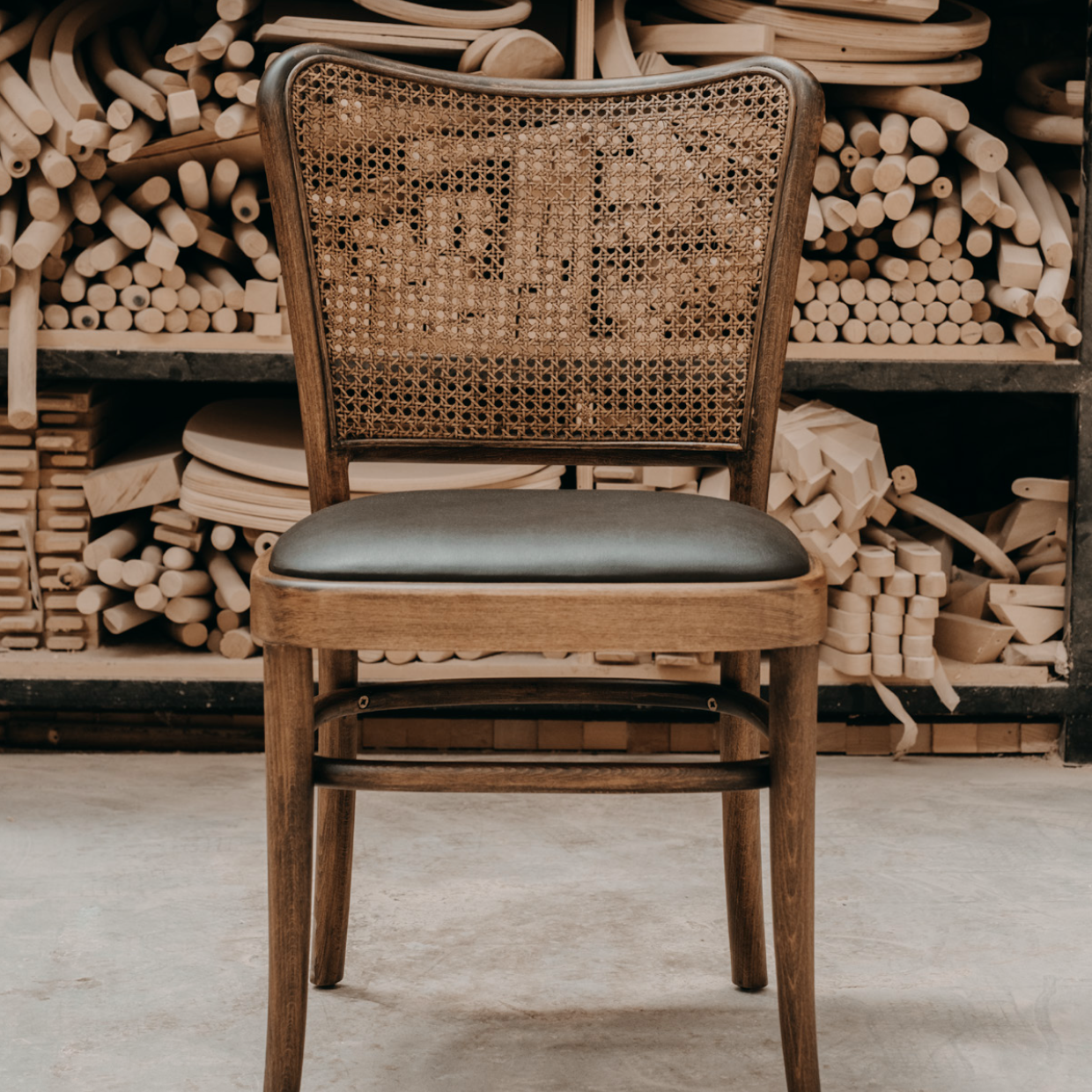 Luxury NOMO oak dining chair with natural Hazeran cane backrest and steam-bent wood frame for high-end dining rooms by Nuovo Kitchens Vancouver.