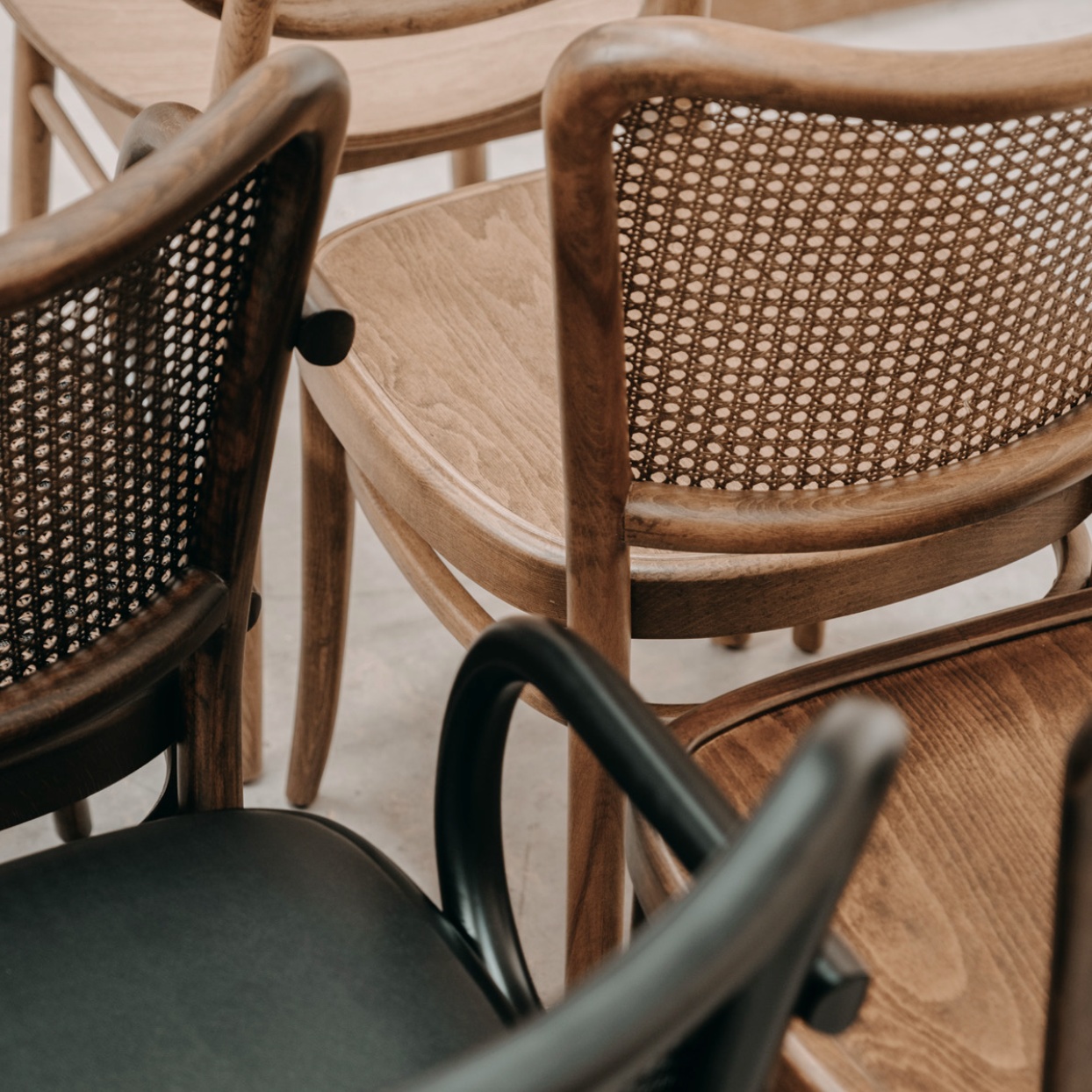 Luxury NOMO oak dining chair natural Hazeran cane backrest and steam-bent wood frame detail. Artisan chairs for high-end dining rooms by Nuovo Kitchens Vancouver.