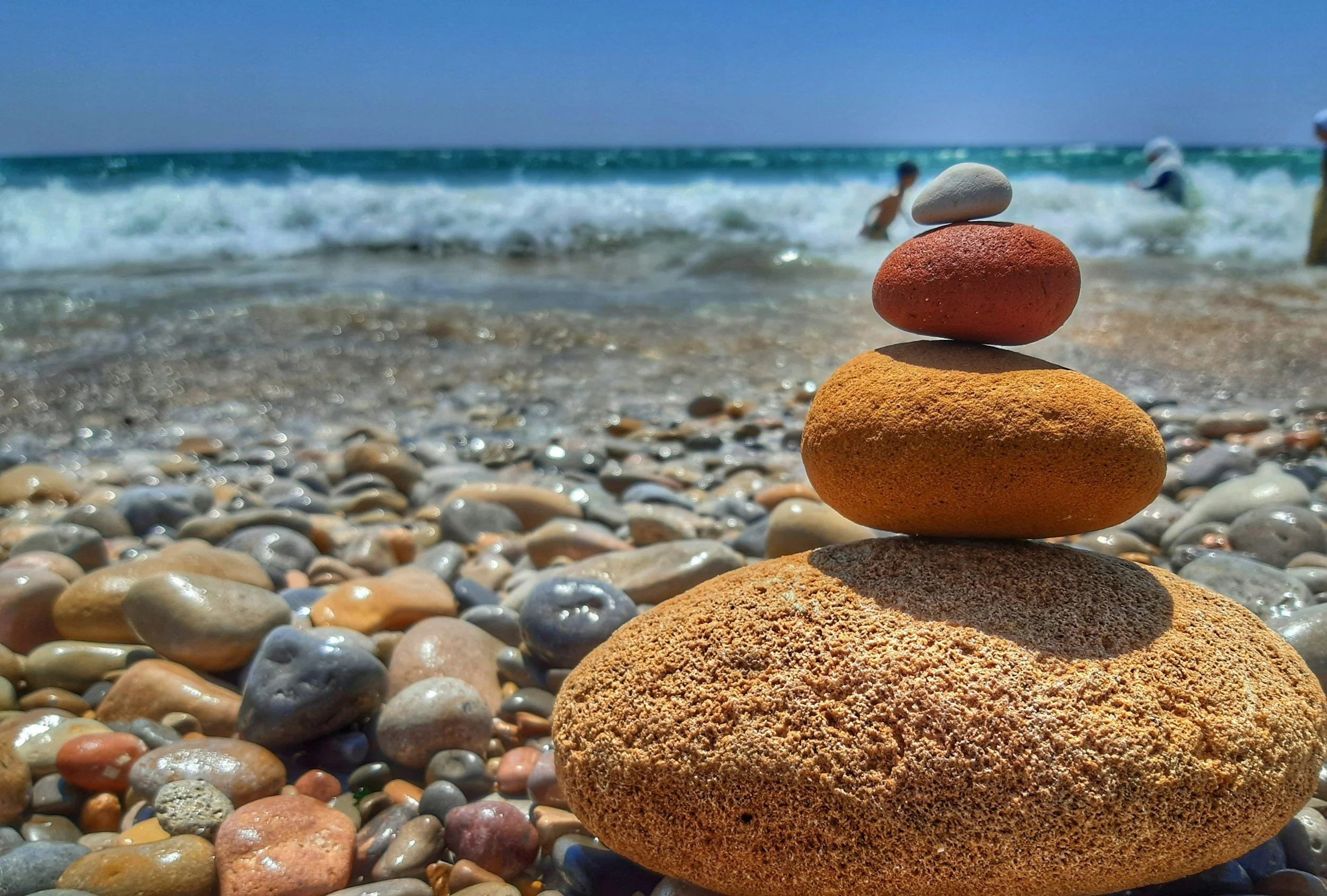 stones balanced on one another on a rocky ocean shore